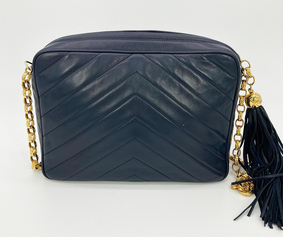 Vintage Chanel Navy Chevron Quilted Tassel Camera Bag in very good condition. Navy lambskin in chevron quilt with gold hardware. Front CC twist lock flap pocket. Fringe leather tassel zip pull. Navy leather interior with one side zipped pocket.