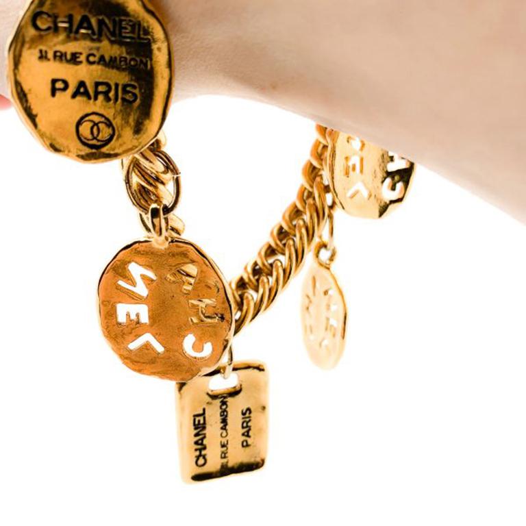 Un fabuleux bracelet à breloques Chanel oversize datant des années 1980. Cette chaîne solide à maillons est ornée de cinq grandes breloques Chanel, dont les breloques du logo découpé et les breloques de la rue Cambon. Ce bracelet célèbre l'héritage