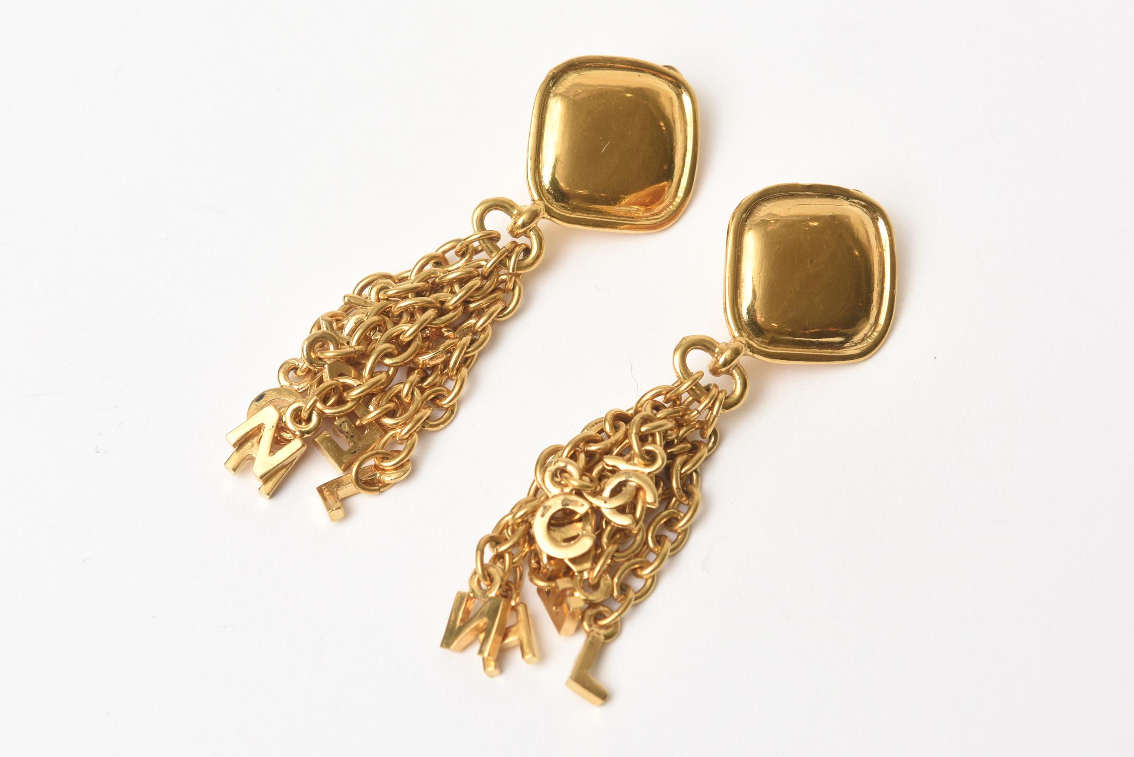 These fun, chic yet sophisticated Chanel clip on dangle earrings have charm like pendants in chain form hanging from the top with CC's. They are gold plated and are dramatic. They are from the 20th century of the 90's. They can go all seasons day to