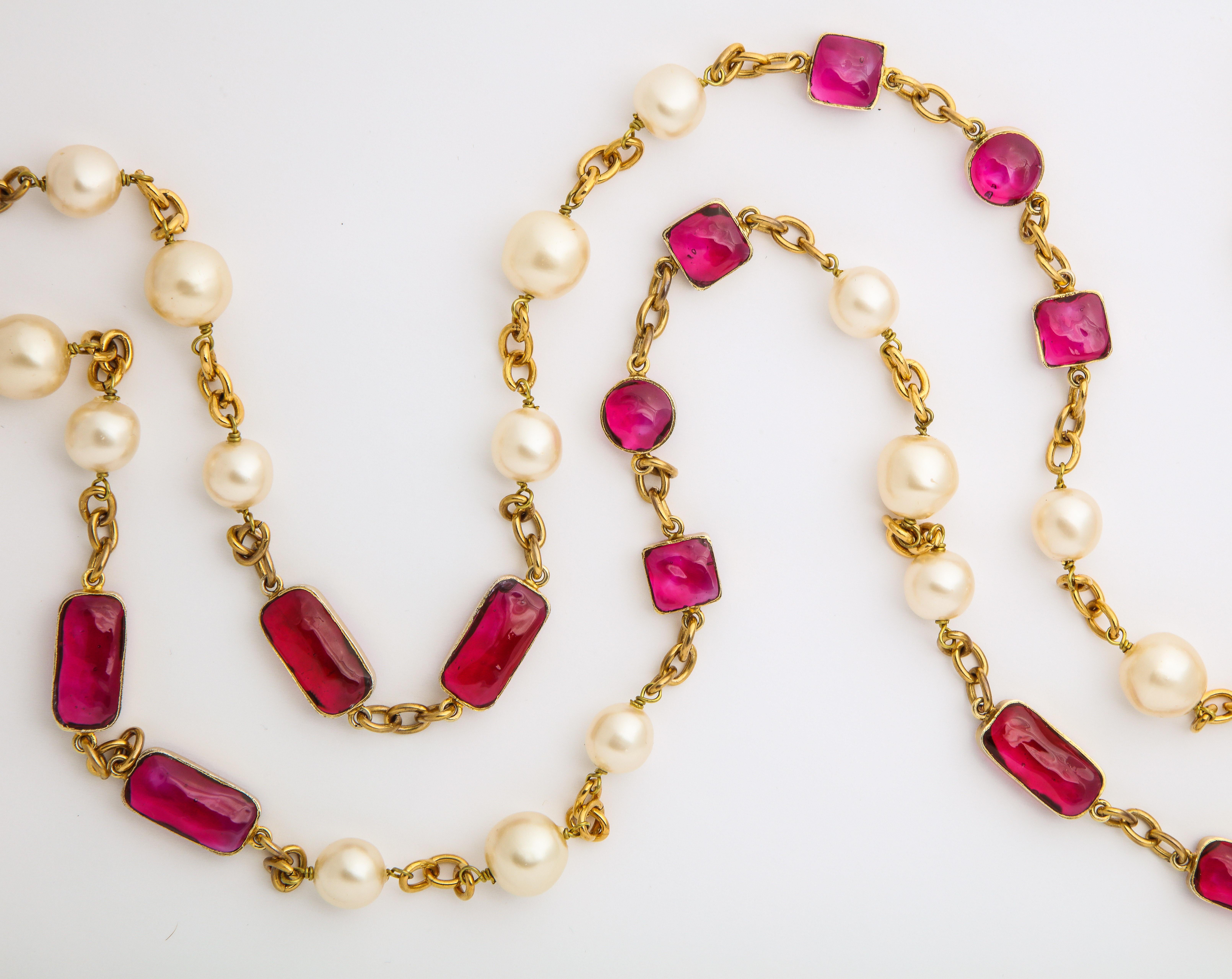 This Vintage Chanel Pearl and raspberry Red poured glass necklace is exceptionally long  and can be tripled to be worn as a stunning icollier.  The color is very beautiful.