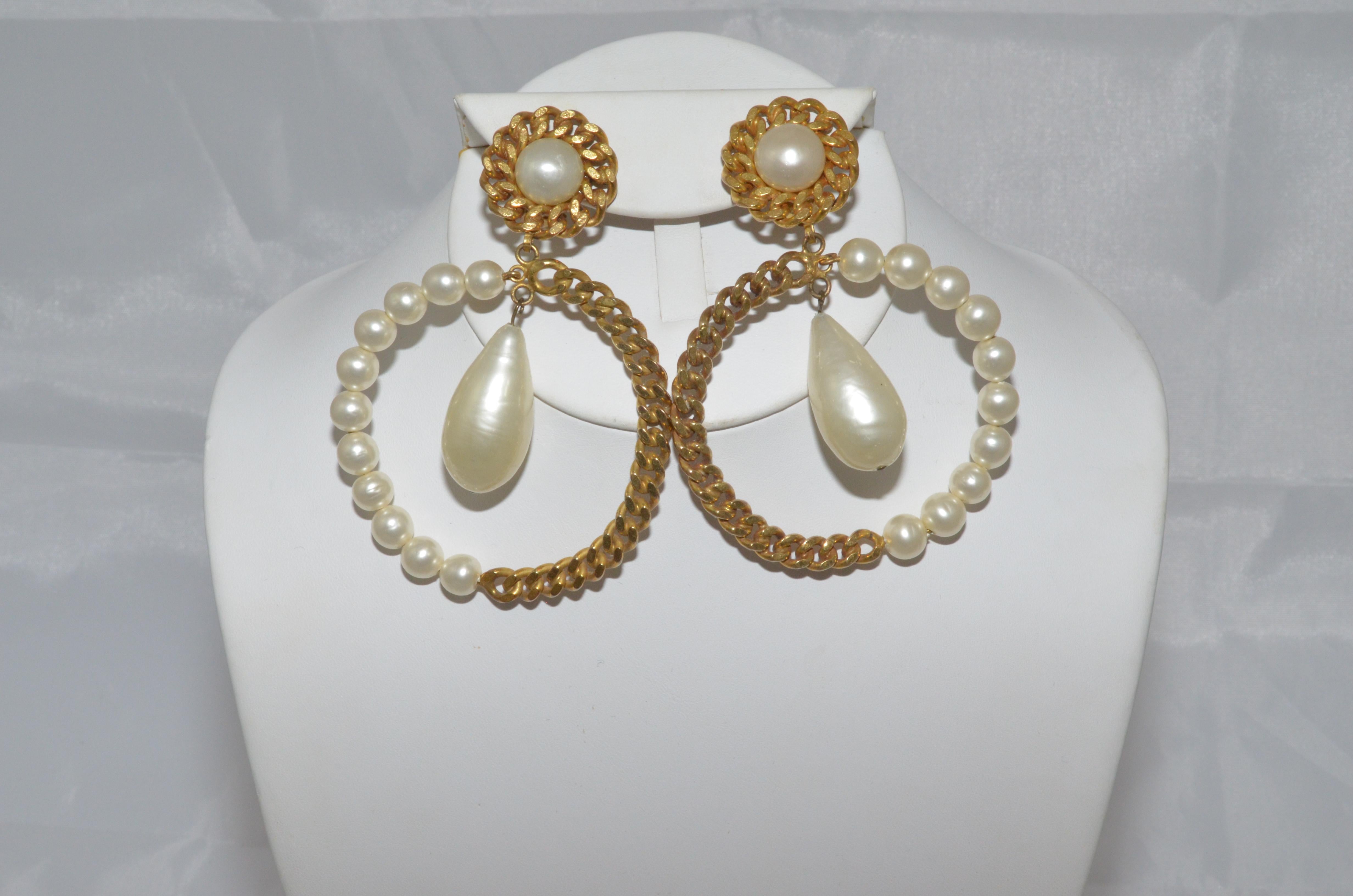 Vintage Chanel earrings featured in a pearl and gold-tone chain hoop with a large tear-shaped pearl that dangles from the top, and a clip-on fastening. Earrings are signed CHANEL, Made in France. Earrings are in excellent vintage condition with some