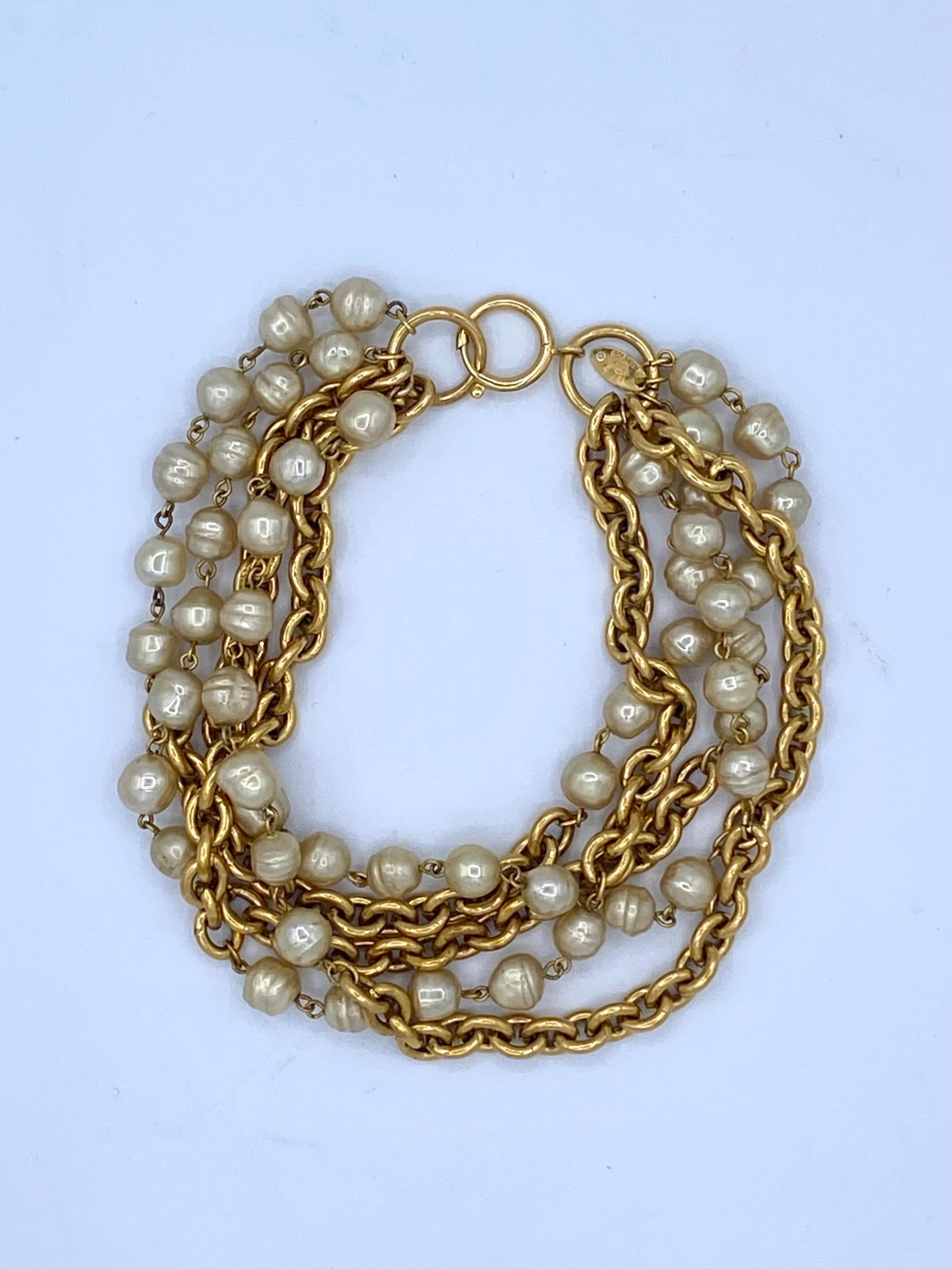 Vintage 1985 Chanel pearl and golden chain choker necklace, 5 rows, round zipper clasp with a small medallion stamped Chanel.
Made in France.
Length 35.5cm
Width 4.5cm
Delivered in a Chanel box.
Some slight traces of use which in no way affect the