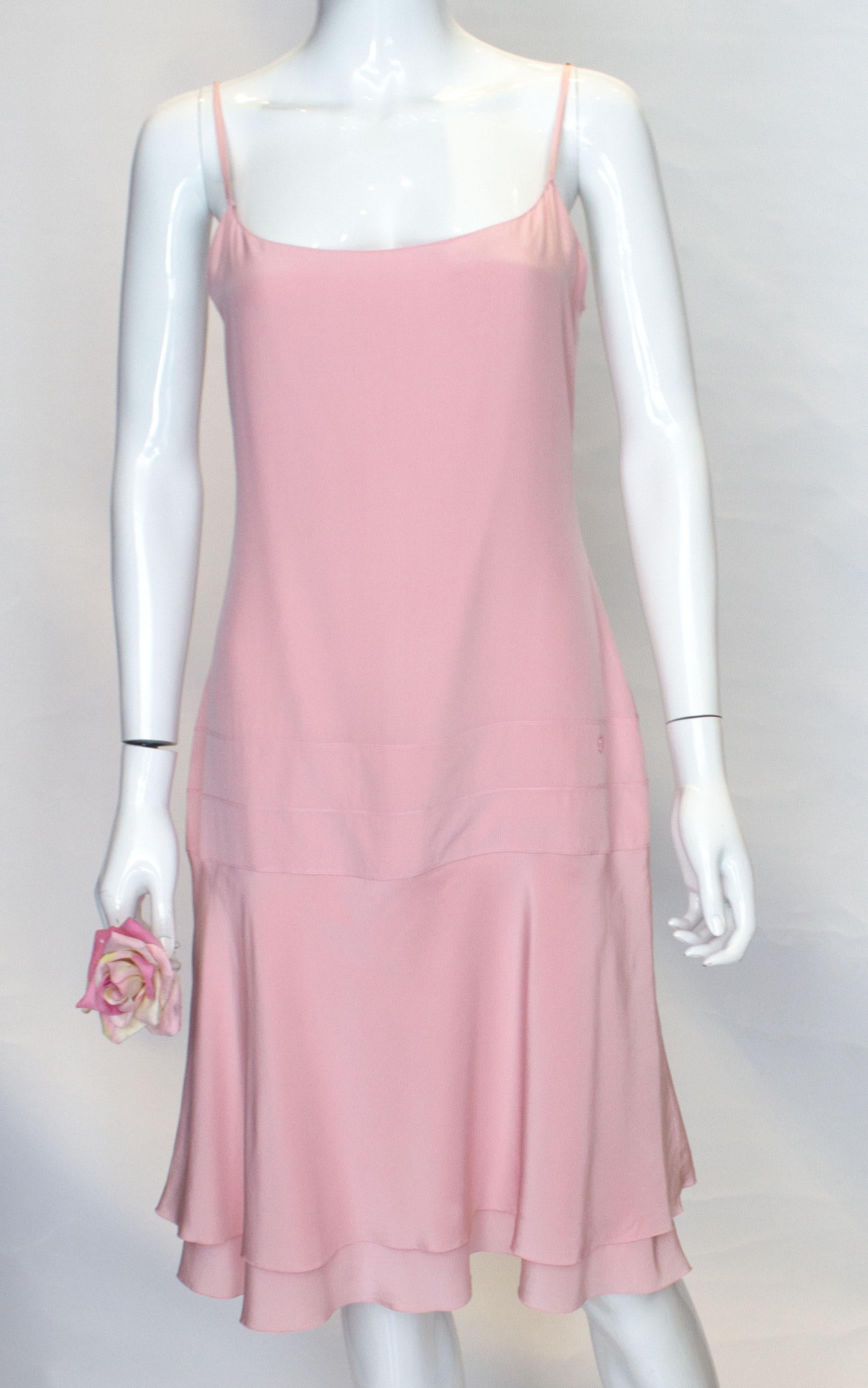 A pretty dress for Summer by Chanel. This dress is easy to wear and the fared hem moves with you as you walk.
It is super soft silk on the outside and lining, and has spagetti straps and a central back zip. There is a subtle Chanel detail at hip