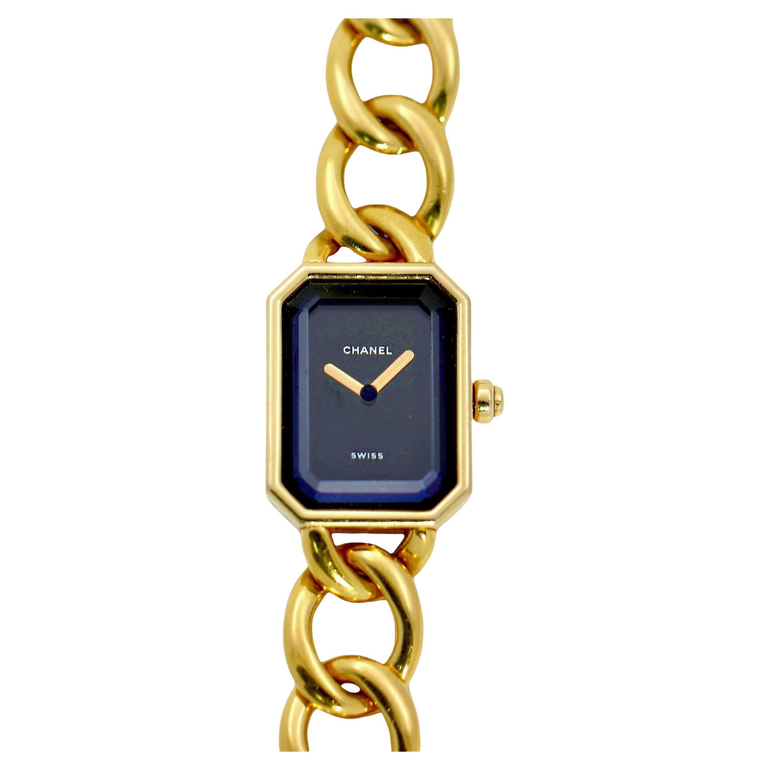 This lovely 18K yellow gold Chanel Premiere quartz ladies wrist watch was  released by the venerated house in 1987. The bold rectangular, clipped corner head measures over 1 inch in length by 3/4 inch in width. The dial is black, bears the company