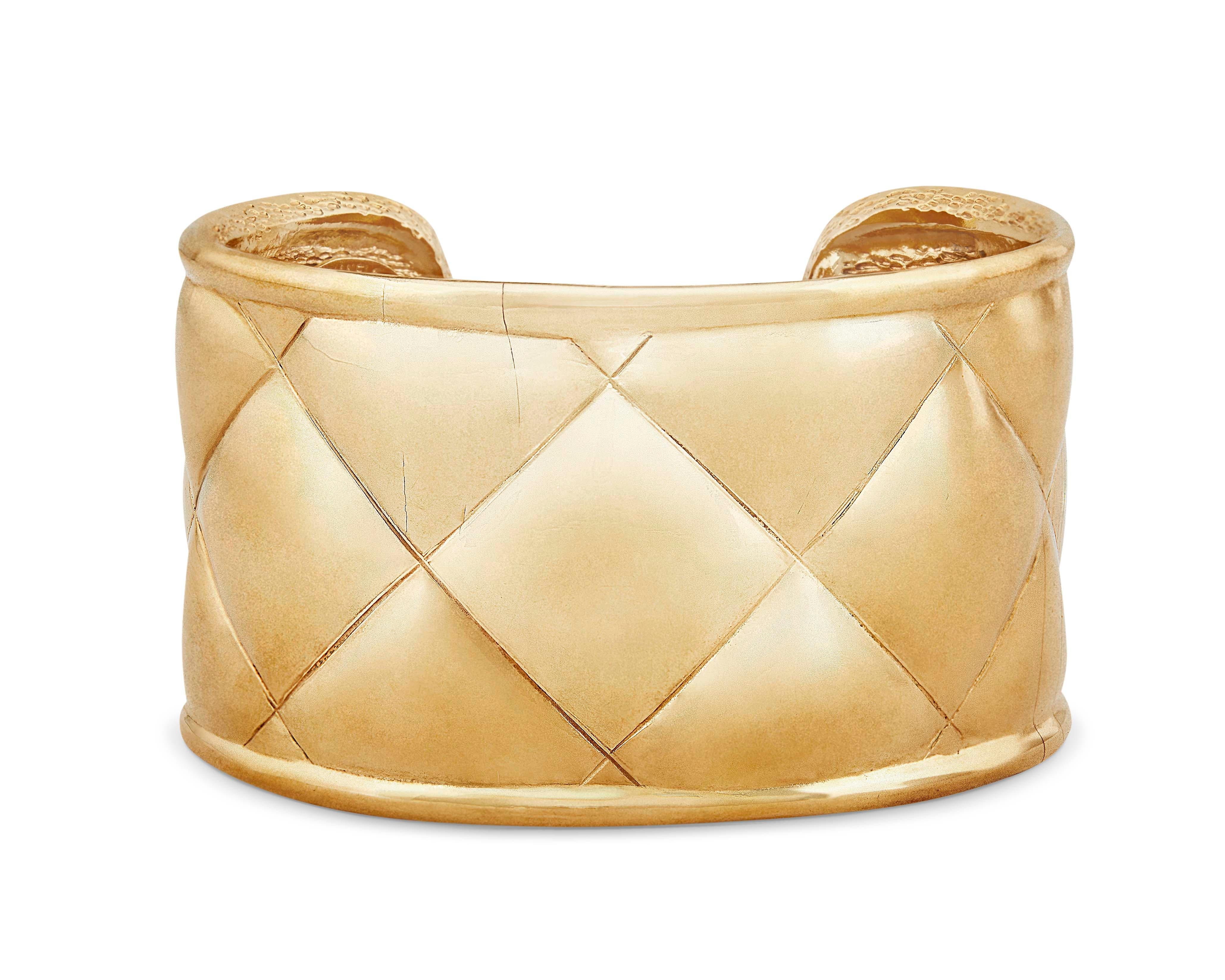 Iconic vintage Chanel Matelasse cuff bracelet in gold plate from the 1980s.  This collector's item features the signature Chanel quilted pattern all around.  Cuff-style bracelet features an open back and slips on.

Bracelet measures approximately 2