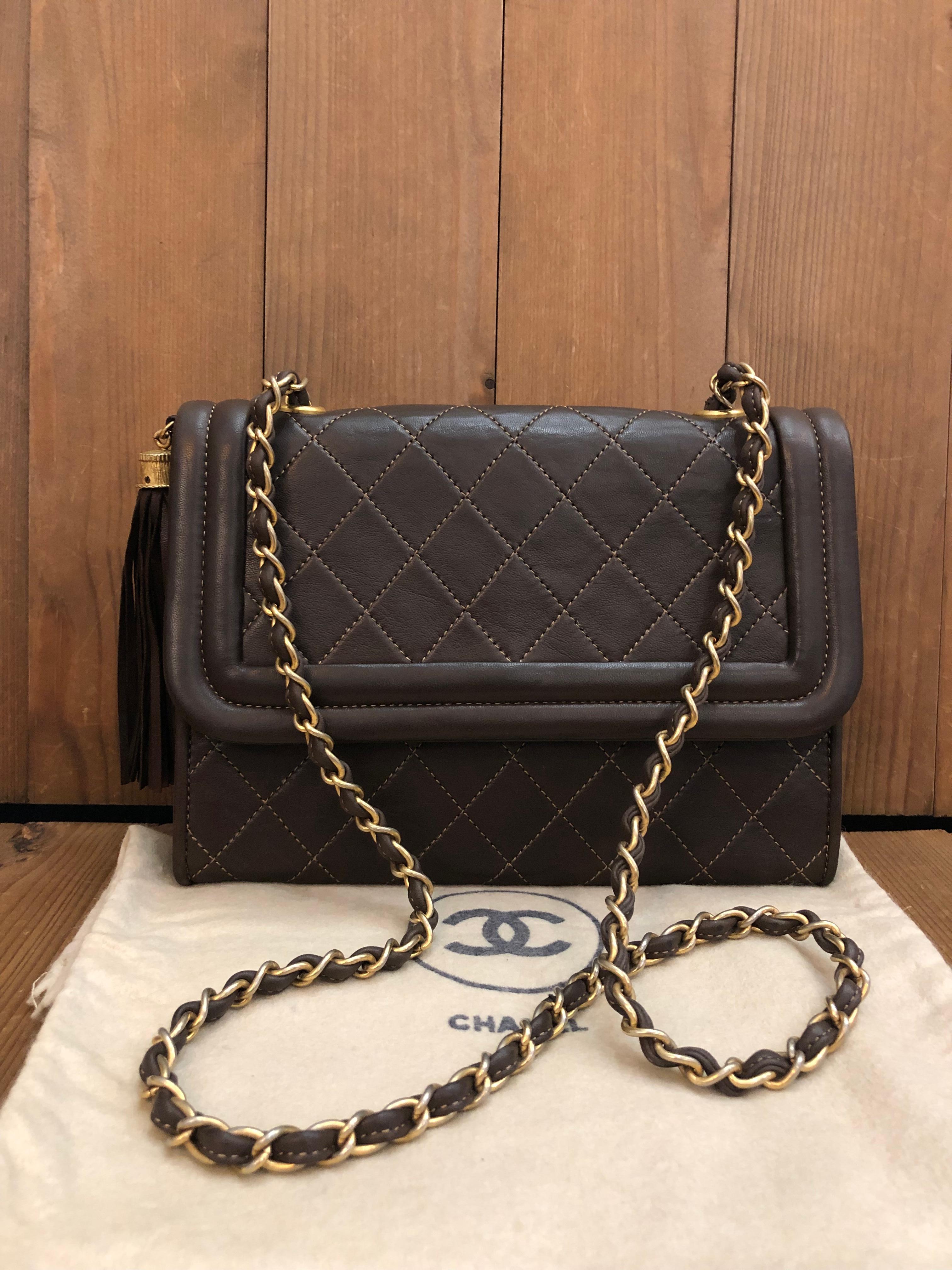 This vintage CHANEL Flap Bag is crafted of diamond quilted lambskin leather in chocolate brown featuring gold toned hardware and adorned with a tassel of the same leather. This Chanel flap bag features a gold toned chain interlaced with brown