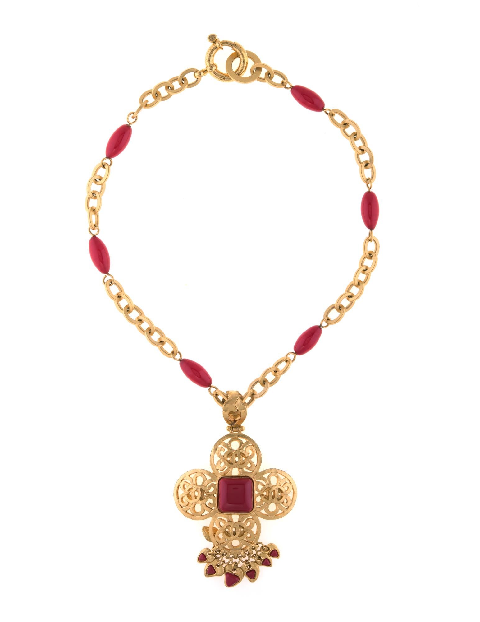 Vintage Chanel red cross necklace crafted in yellow gold tone (circa 1995).

The necklace features a large filigree cross with red resin details. The pendant is attached to a long 20 inch oval link chain. The necklace dates to 1995 from the Spring