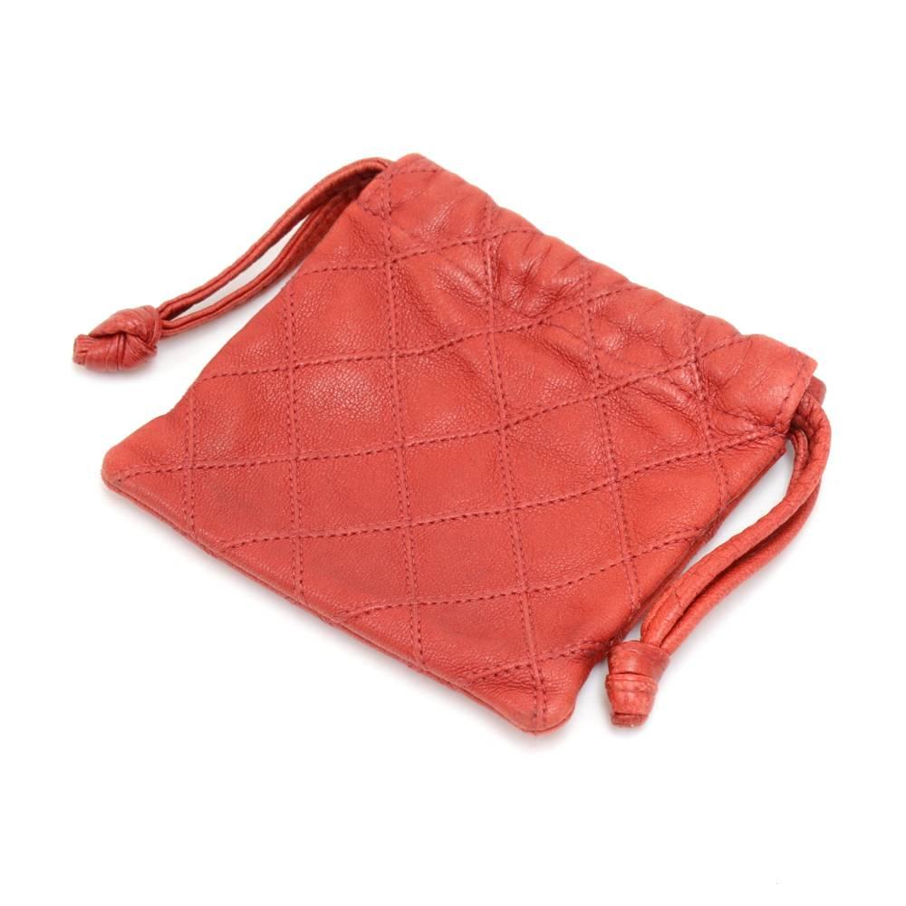 Vintage Chanel pouch in red quilted leather.  Has a small gold-tone CC logo in the front center. Main access secured with drawstring closure. Inside has a red fabric lining. Perfect to keep your small items organized.  A very cute vintage item to