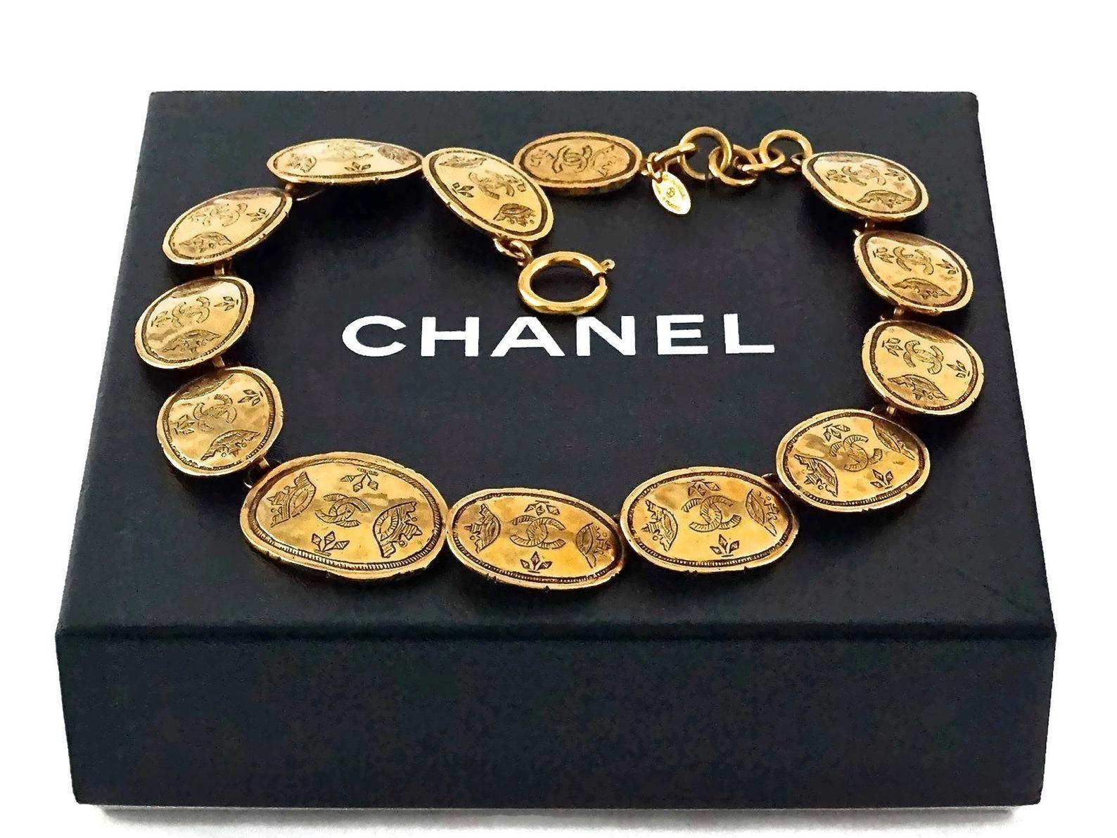 Vintage CHANEL Regal Crown Logo Coin Medallion Choker Necklace

Measurements:
Height: 0.90 inch (2.3 cm)
Wearable Length: 15.74 inches (40 cm) until 16.92 inches (43 cm)

Features:
- 100% Authentic CHANEL.
- Oval coins/ medallions with engraved CC