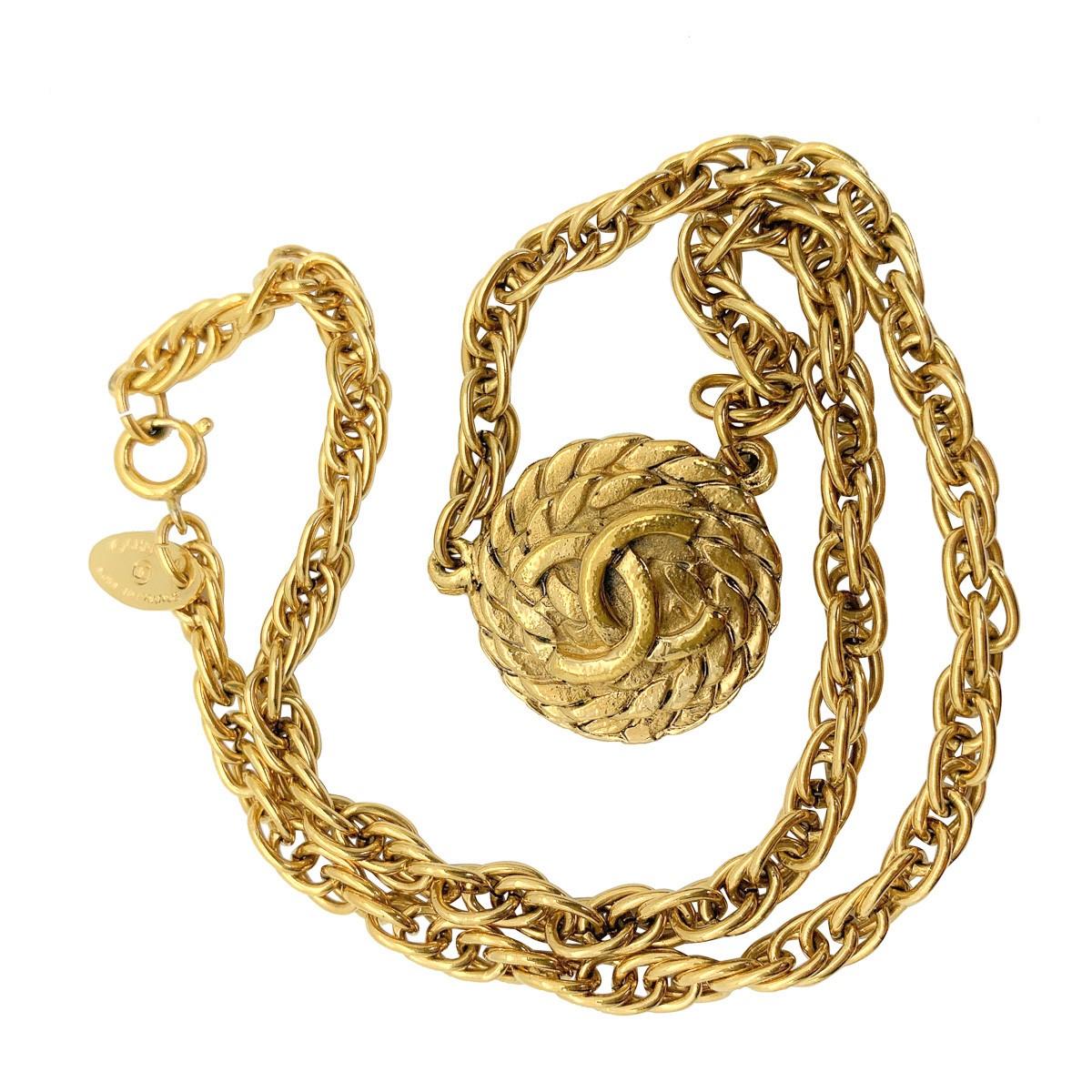 Un collier vintage iconique de Chanel avec le logo en forme de corde et les C emboîtés sur un médaillon en forme de corde enroulée. Sertie d'une chaîne épaisse, cette pièce fera sans aucun doute tourner les têtes grâce à son héritage.

Vintage