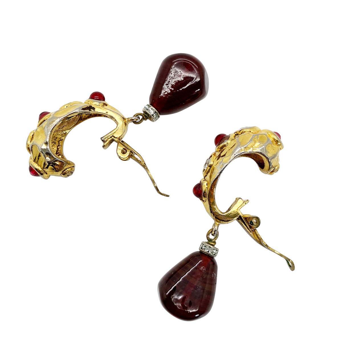 A beautiful pair of statement vintage Chanel pâte de verre earrings dating to the late 1970s, early 1980s. Featuring a huggie style clip top set with paste chatons and poured glass or pâte de verre cabochon stones. Finished with a statement pâte de