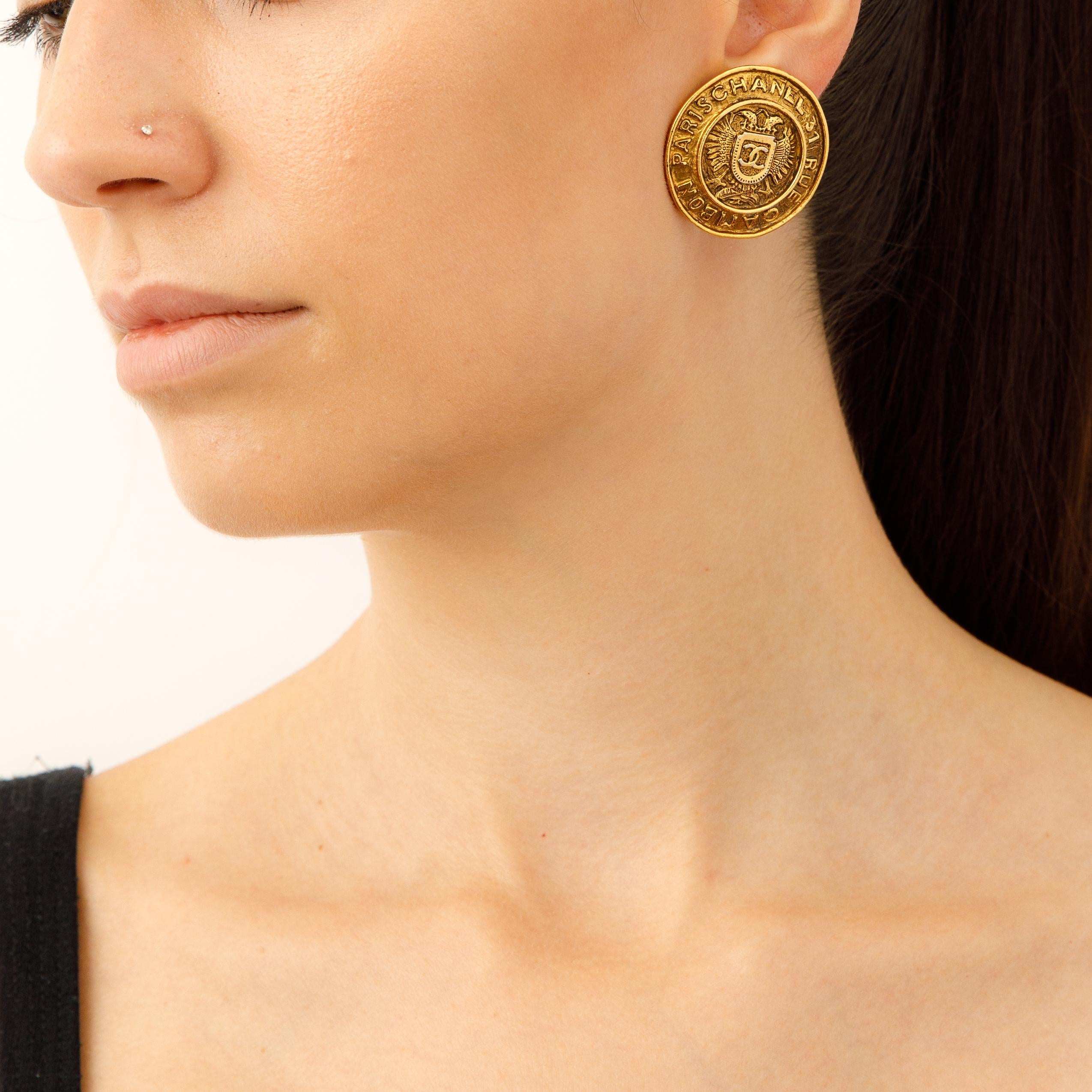 Gönnen Sie sich ein exquisites Stück Geschichte mit diesen Vintage Chanel Rue Cambon Crest Ohrringen. Von den goldenen Farbtönen bis zu den ikonischen Wappendetails sind diese Ohrringe ein ikonisches Statement von zeitloser Eleganz. Diese