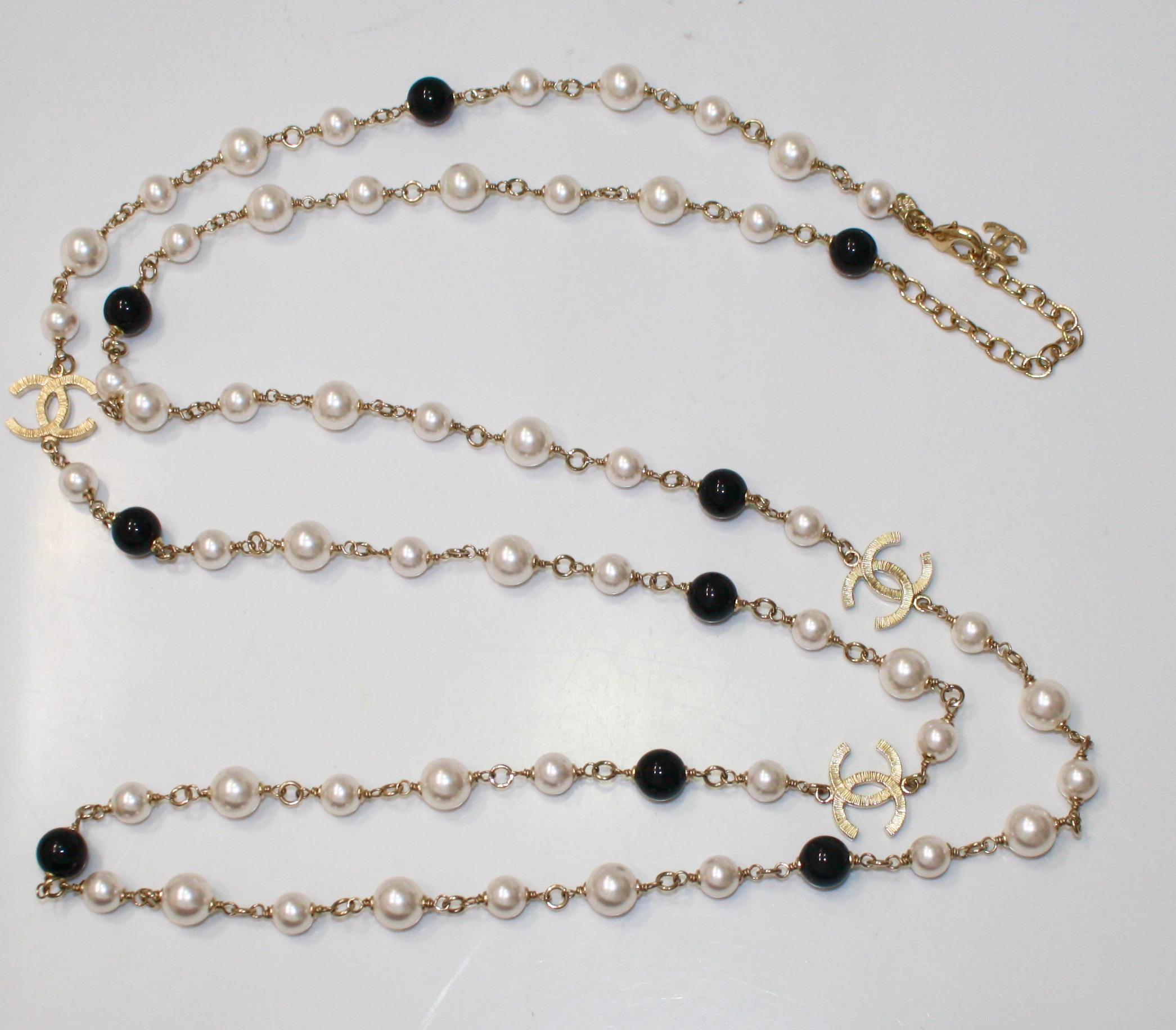 Black and white glass pearls on pale gold metal with 3 CC motifs . From the 2007 fall collection. Signature by the clasp
