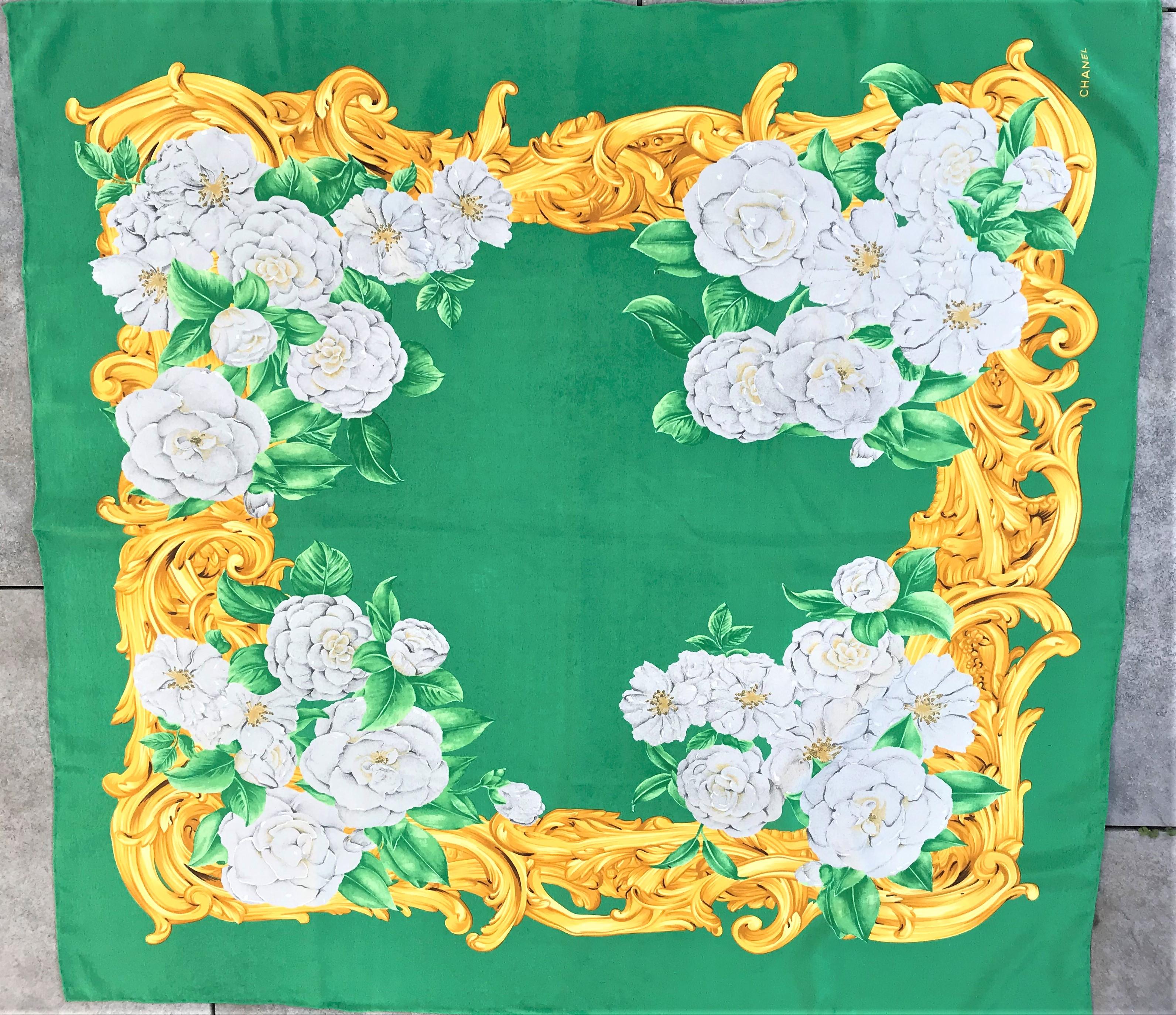 Vintage-Seidenschal von Chanel, bedruckt mit der Lieblingsblume von Coco Chanel, der Cameilia, auf grünem Grund.
Grüner Grund, verschiedene Kamelien in Hellgrau mit grünen Blättern und goldfarbenen Rocaillen umrandet. Der Schal ist handgerollt und