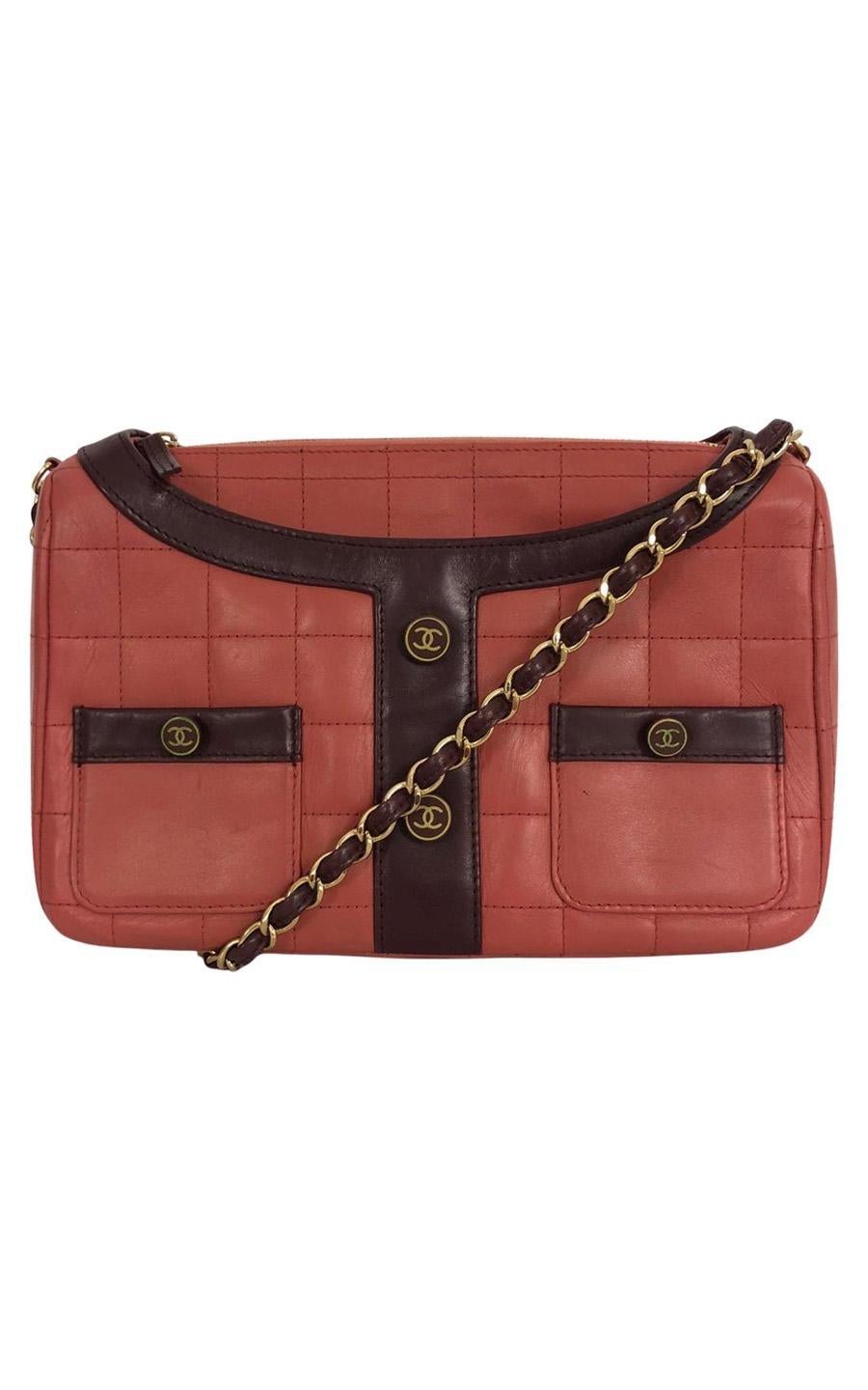 Chanel shoulder bag in red lambskin leather with purple leather details. The bag has gold colored hardware. The bag opens with a zipper. The red leather inside features one main compartment. In front, there are four slip-in pockets, at the back