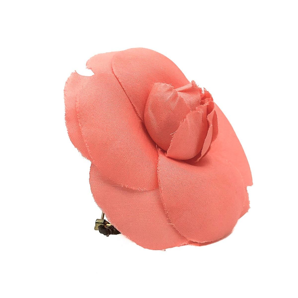 A salmon pink Vintage Chanel Camellia Corsage. Crafted in silk with a pin back. In very good vintage condition, signed, approx. 6.8cms. This is a delicate floral piece from the House of Chanel and would require careful wear and storage to preserve