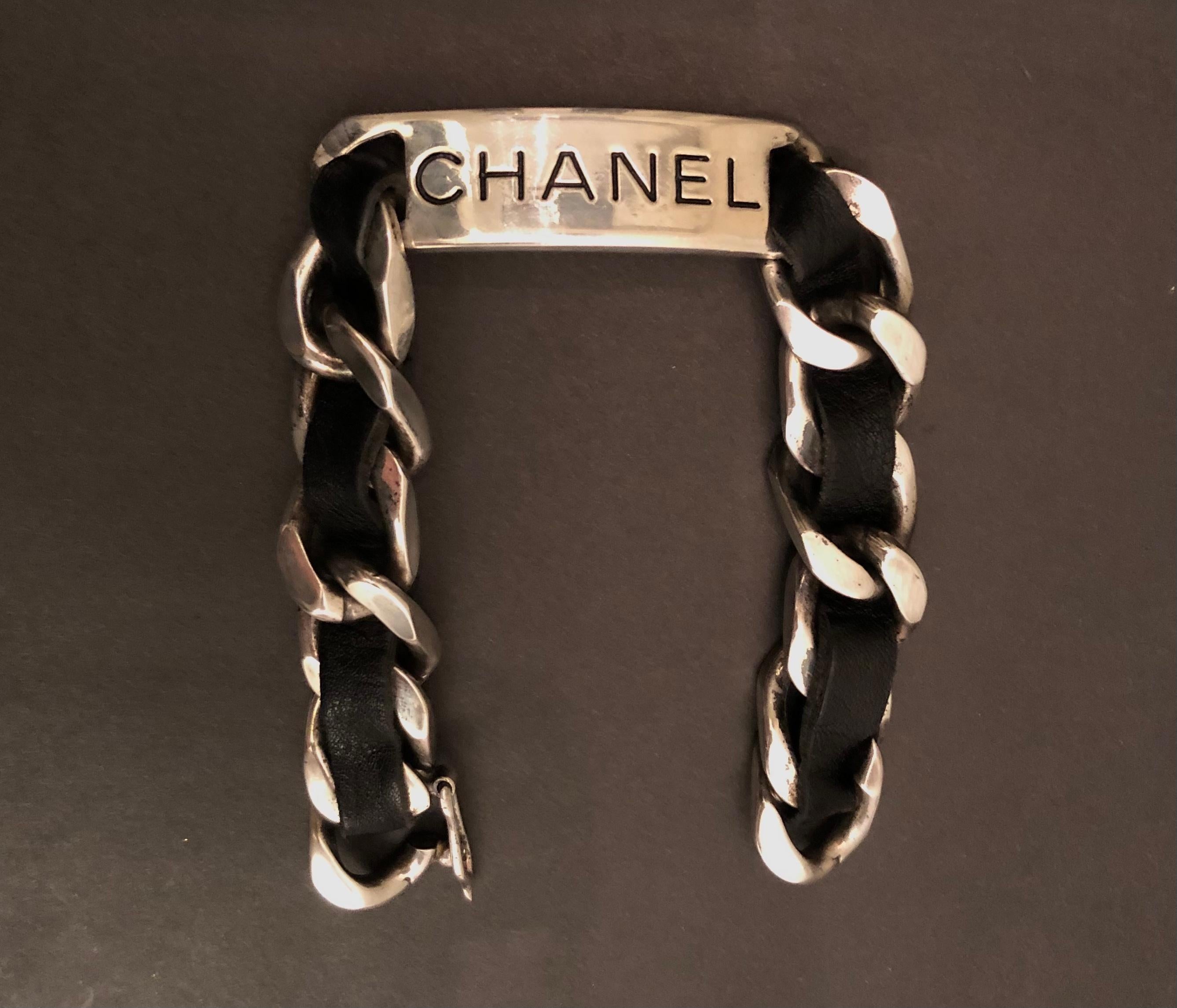 This vintage Chanel silver toned chain link bracelet is crafted of silver toned metal interlaced with black lambskin leather. Hook fastening. Stamped CHANEL 96P, made in France. Inner circumference measures approximately 20cm. Comes with