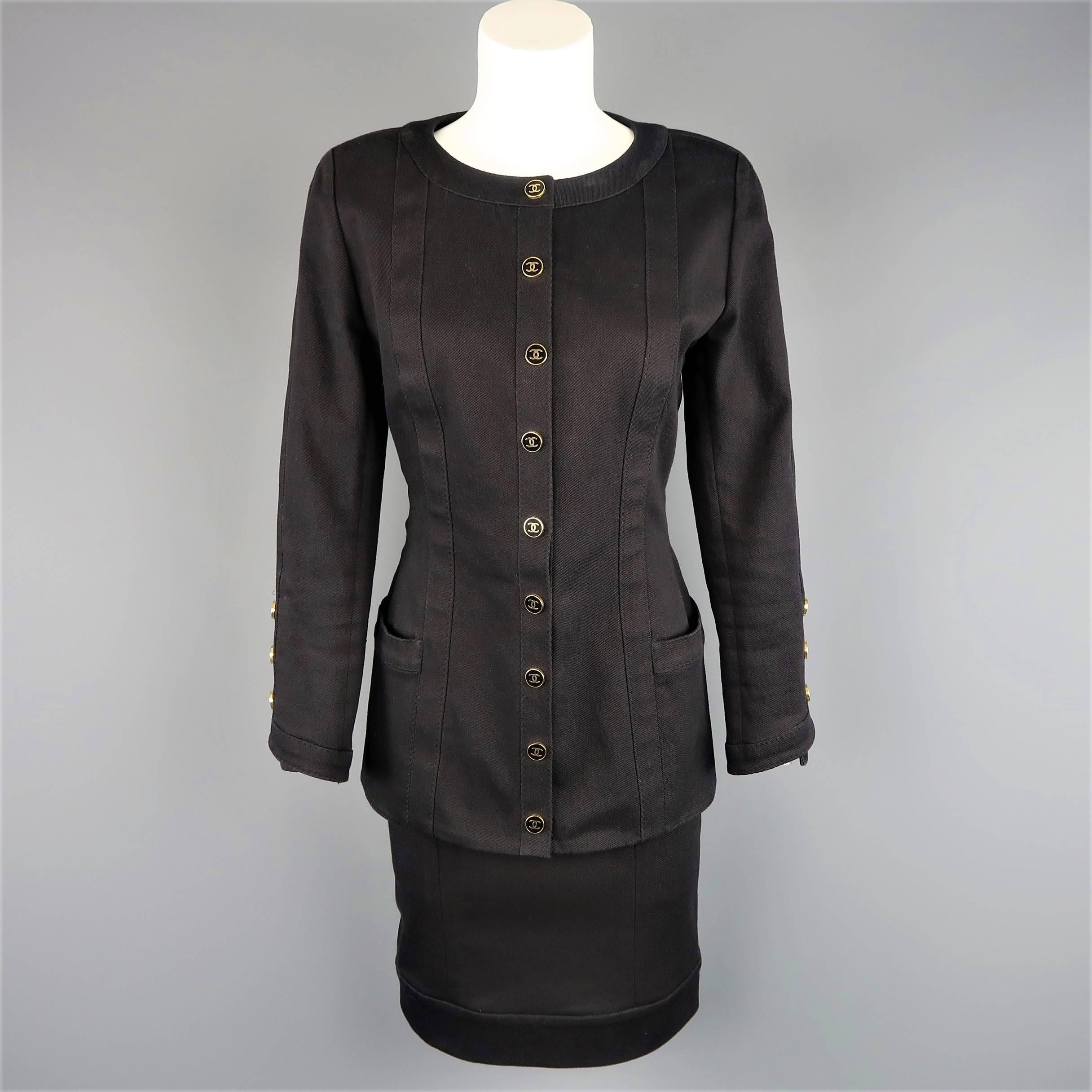 Vintage CHANEL suit comes in black cotton denim and includes a round neck, collarless jacket with padded shoulder, side pockets, and gold tone black enamel CC logo snap closures and matching pencil skirt. Minor wear. Made in France.
 
Good Pre-Owned