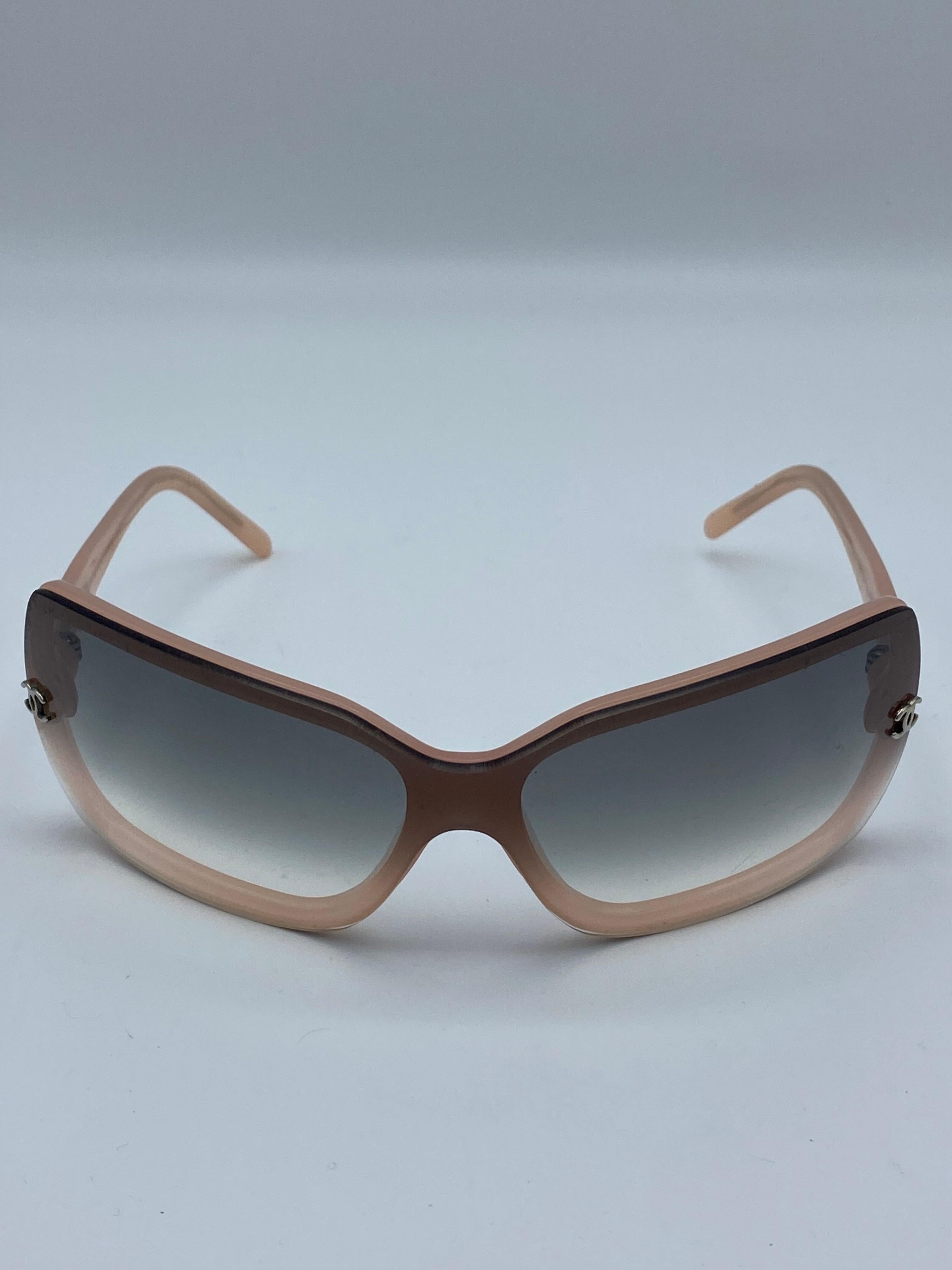 Détails du produit :

Les lunettes sont dotées de verres gris dégradés, d'une monture rose et d'une monture CC  sur les côtés.