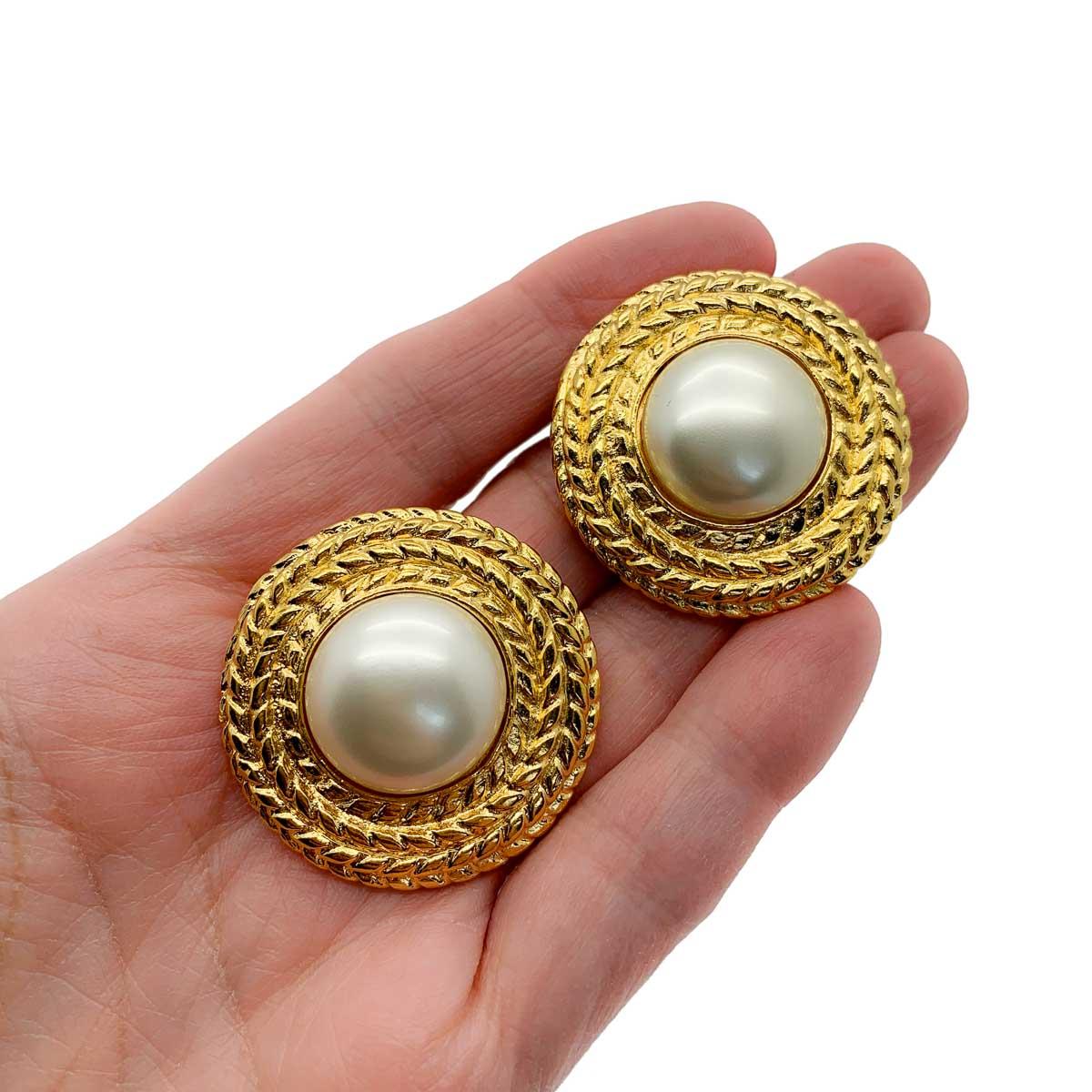 A perfect pair of vintage Chanel pearl rope earrings. Featuring a large half pearl set within a broad rope style mount. Classic Chanel.

Vintage Condition: Very good without damage or noteworthy wear. Immaculate condition.
Materials: Gold plated