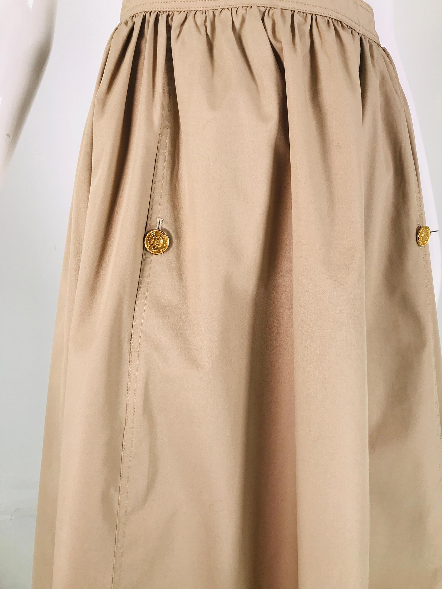Vintage Chanel tan poplin gathered skirt with button front pockets. Band waist is has a horizontally stitched waist band, the skirt is gathered with hip front pockets that close with a gold logo button each. Safari style skirt is perfect for travel.
