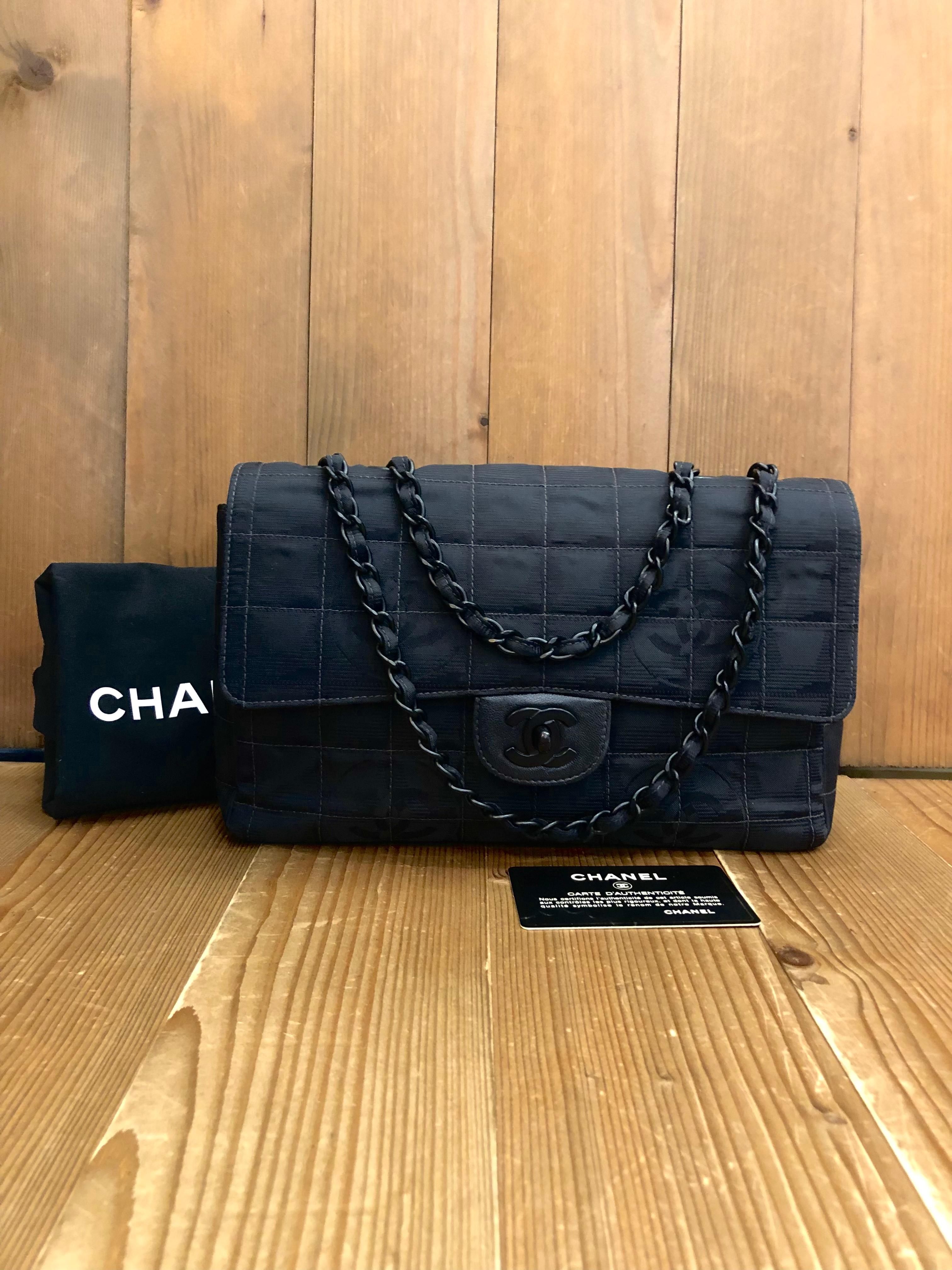This CHANEL classic single flap bag is crafted of quilted Chanel’s Travel Line nylon in super black and black enameled hardware. Front flap CC turn-lock closure lined with black lambskin leather opens to a black nylon interior with a zippered pocket