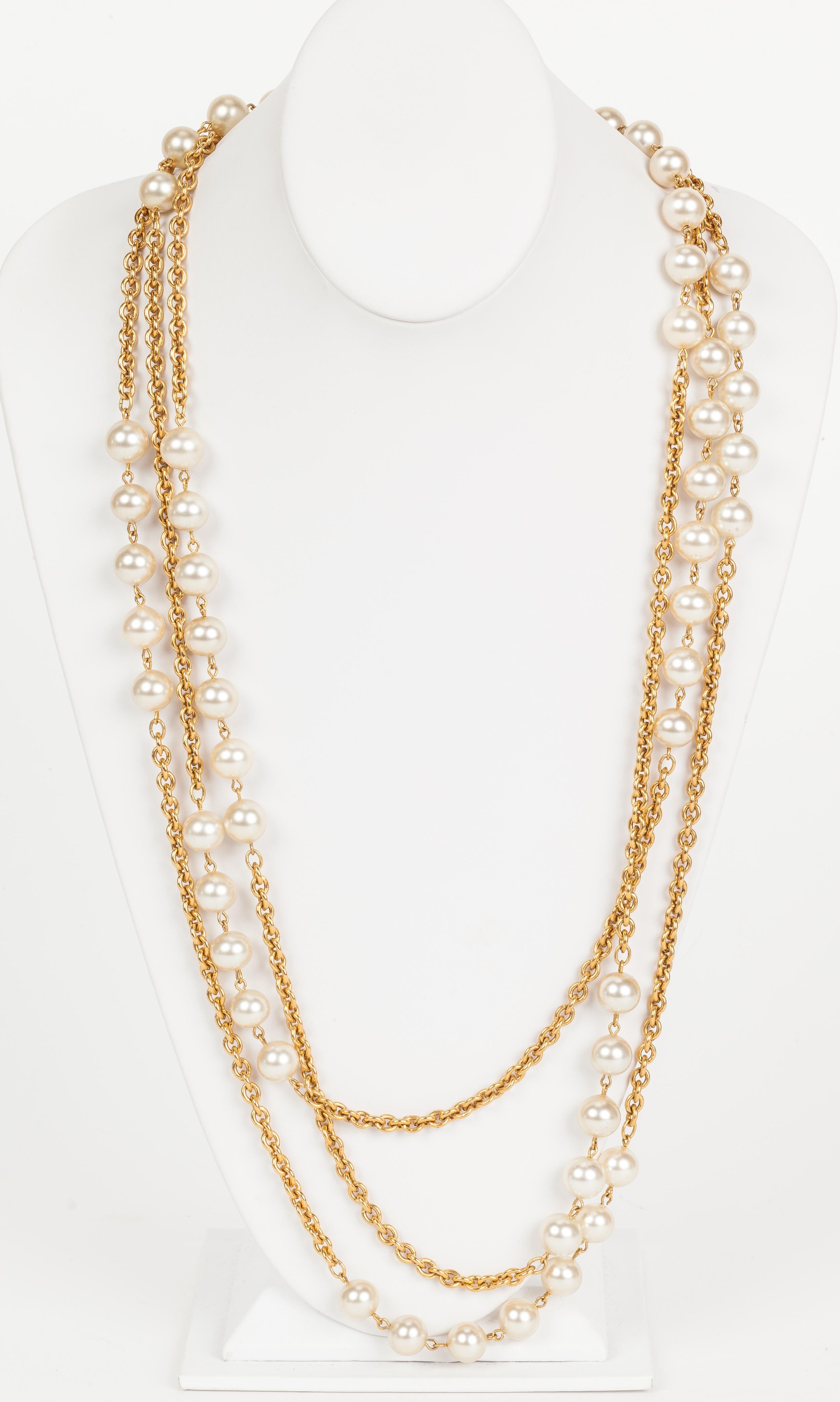 This super chic Chanel necklace is made of three separate strands of alternating pearl and rolo chain design. The longest strand boasts a 19