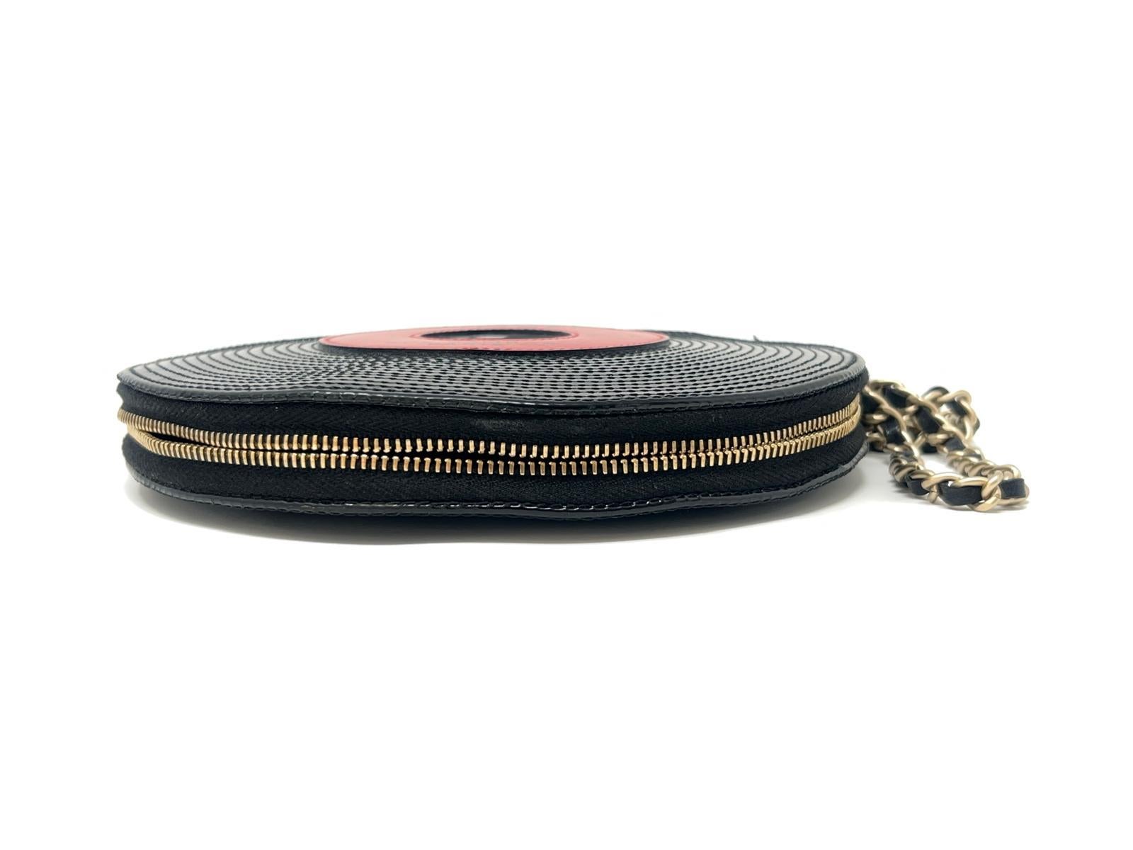 Ce magnifique bracelet Chanel en forme de disque est une pièce maîtresse, en cuir verni noir autour d'un cercle rouge portant l'inscription 