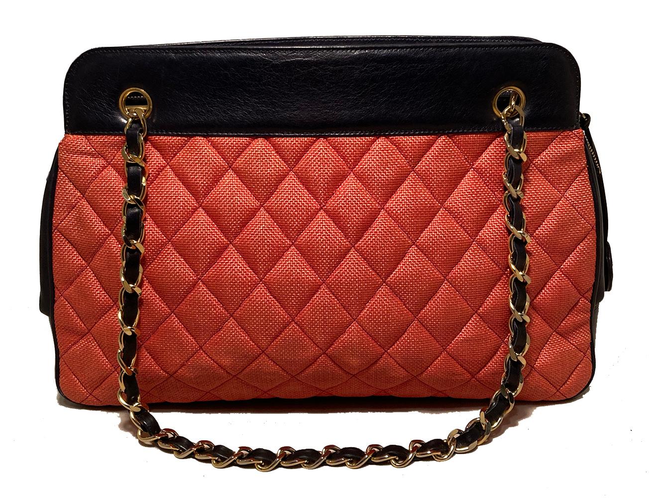Vintage Chanel Woven Raffia and Leather Shoulder Bag Tote in very good condition. Woven coral quilted raffia along front and back exterior trimmed with navy lambskin leather and shining gold hardware. Removable woven chain and leather shoulder