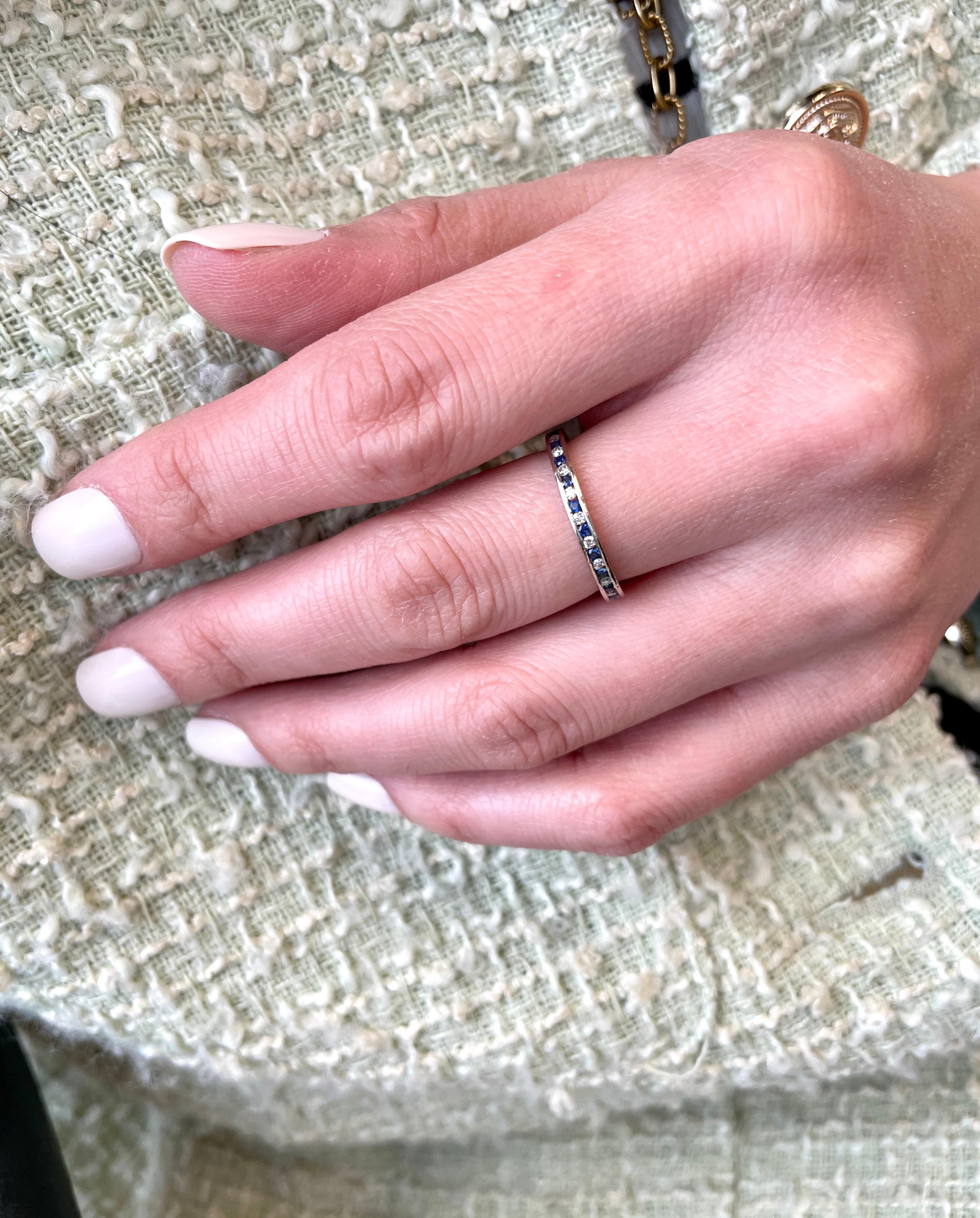 This stunning piece showcases the timeless beauty of vivid blue sapphires and colorless diamonds. They are channel set in an alternating pattern throughout the ring, creating a mesmerizing design. The ring is crafted in 18K white gold. The bright