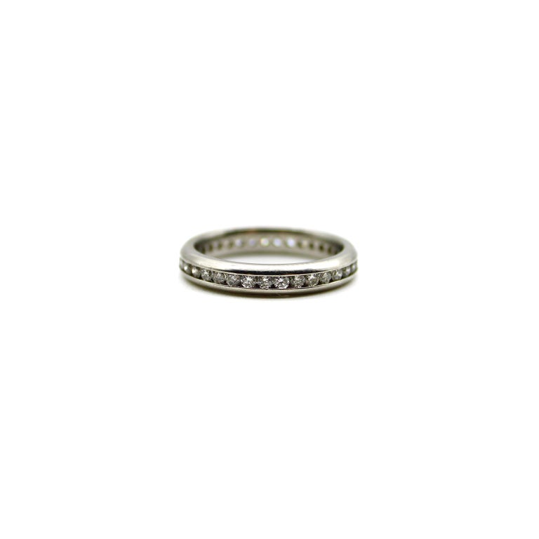 This platinum eternity band sparkles with 35 round cut natural diamonds, channel set elegantly into the band. The ring contains .70 of a carat of diamonds that bring a shimmering line to the finger. The diamonds are nestled snugly into place, set