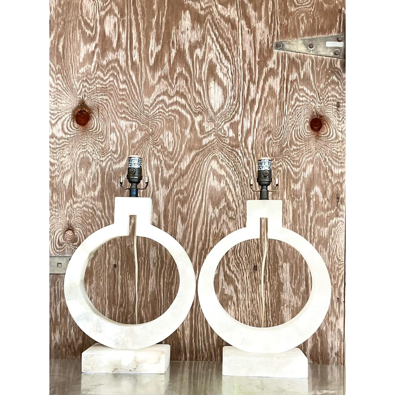 A fabulous pair of vintage Contemporary table lamps. Designed by EF Chapman for Visual Comfort. A chic faux alabaster composite in a modern ring shape. Acquired from a Palm Beach estate.

The lamps are in great vintage condition. Minor scuffs and