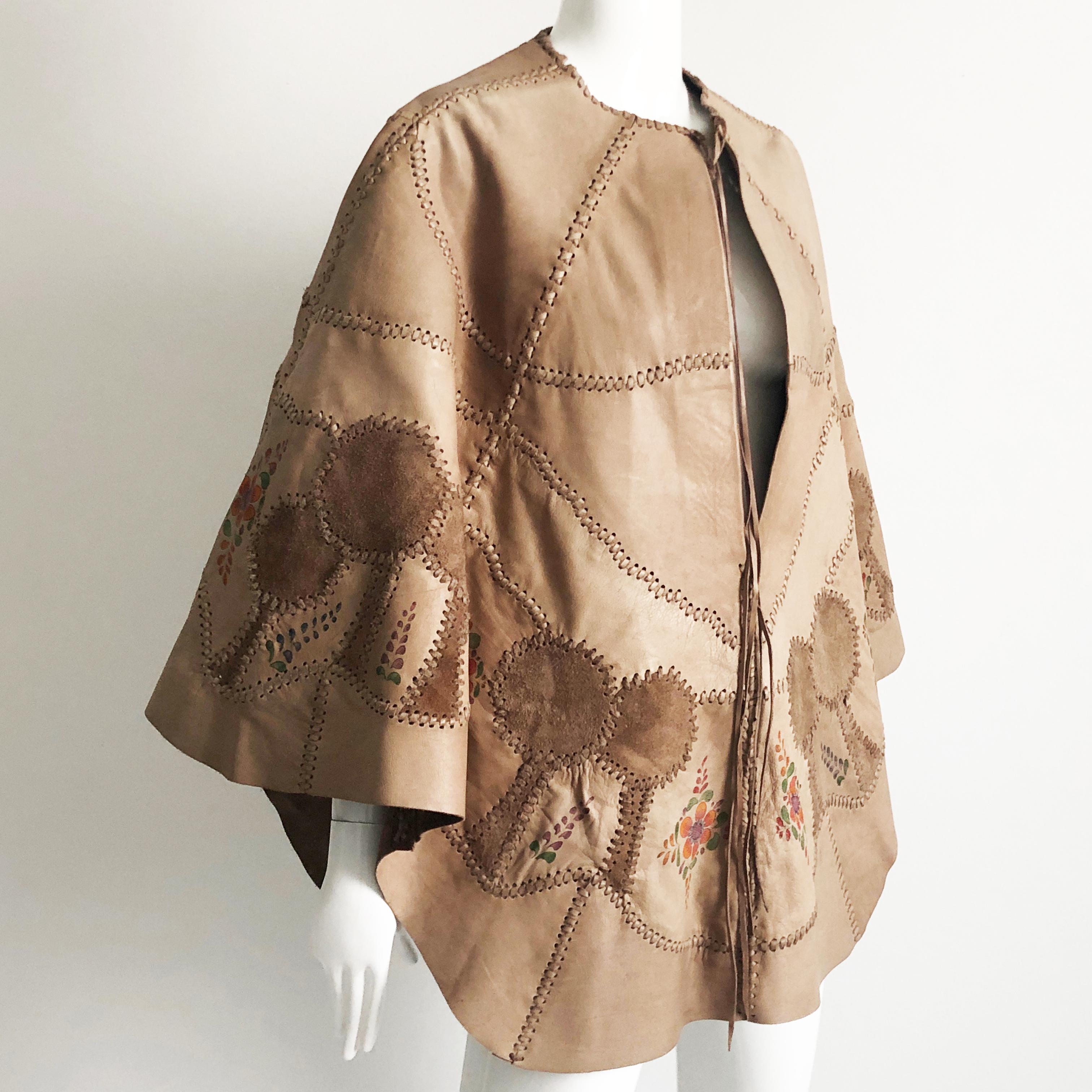 Authentic, preowned, vintage CHAR Leather whipstitched poncho or cape with handprinted florals, made in the 70s. Unlined, fastens at collar with leather strip ties. Perfect festival or boho look (and so hard to find nowadays especially in this color