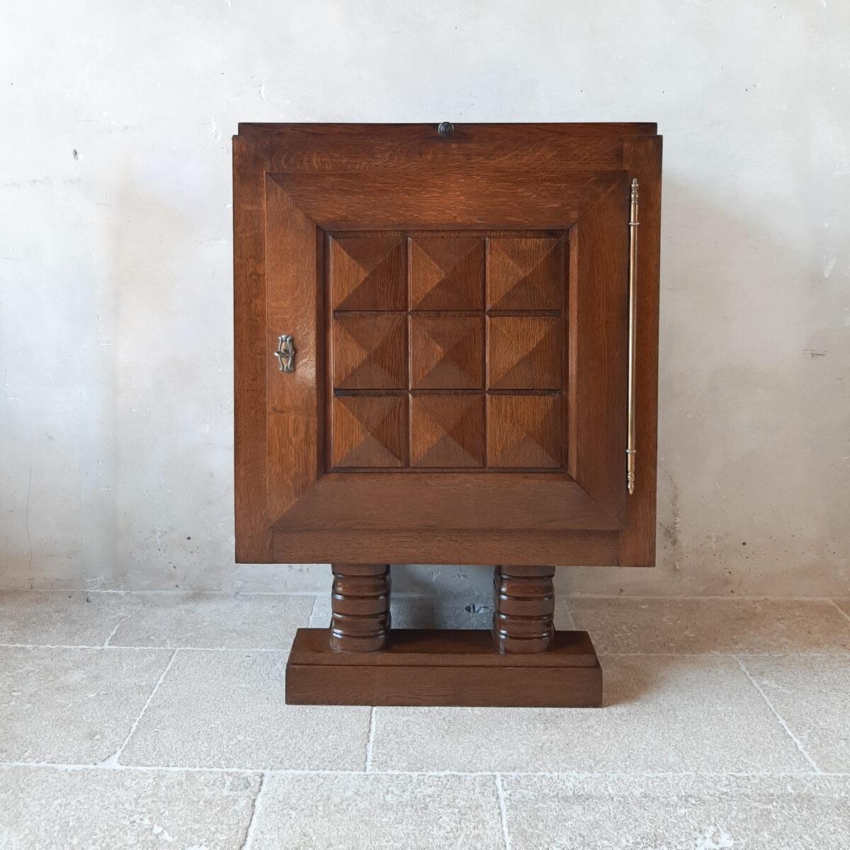 Midcentury vintage Charles Dudouyt wall cabinet. This Brutalist cupboard or bar cabinet in it's original darkened brown oak has geometrical, graphic details on the door, which is a signature relief seen often on Charles Dudouyt work and shows its