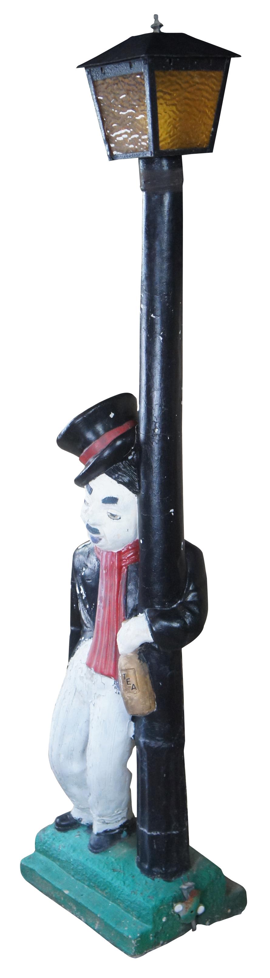 Mid 20th century Charlie Chaplin electrified concrete post light. Great for indoor or outdoor use. Features Charlie dressed in white and black with red scarf and top hat. He is leaning against a street light holding a bottle marked Tea. Wiring and