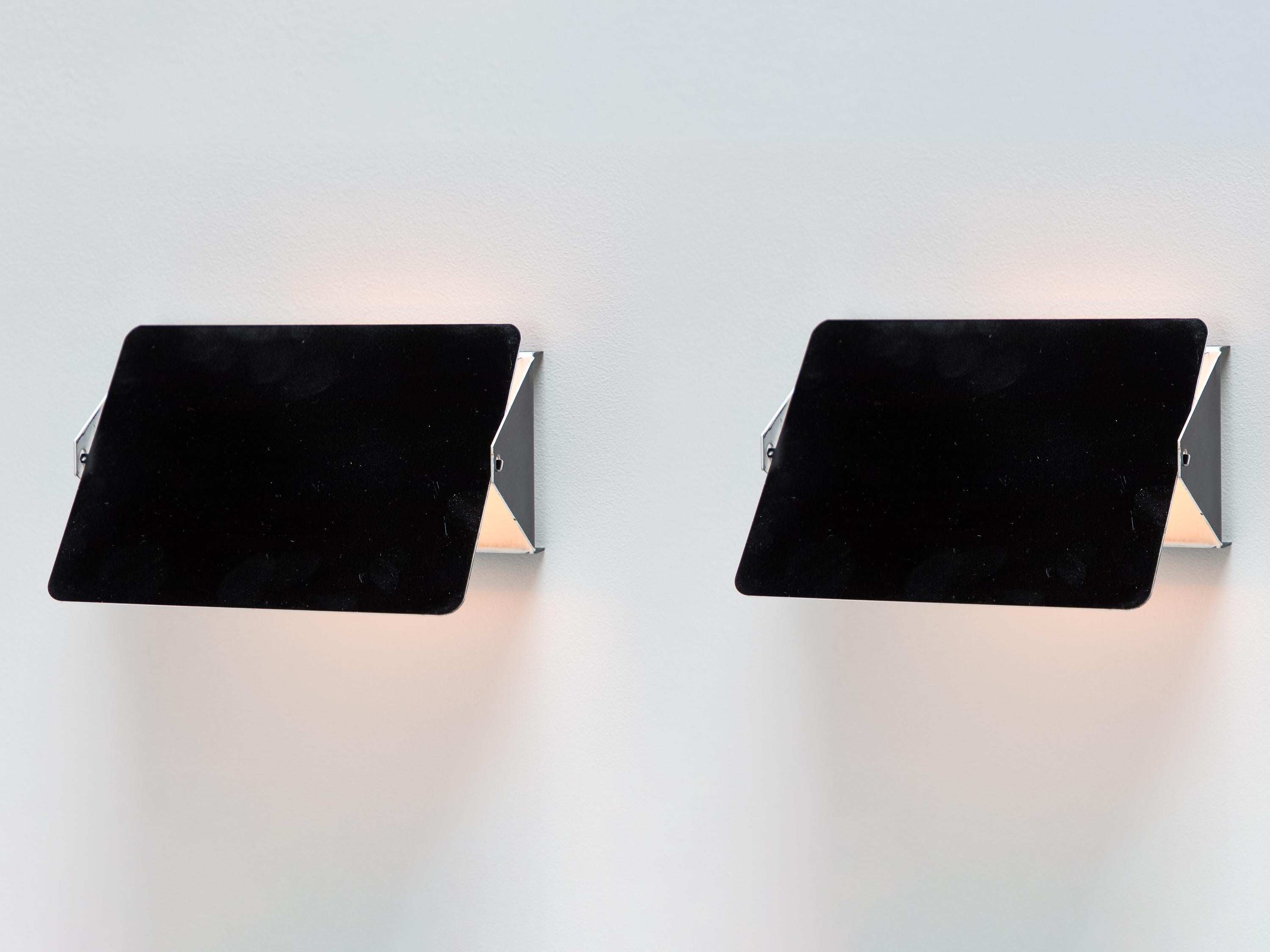 CP1 wall lights, designed by Charlotte Perriand for the iconic Les Arcs ski resort.  Crafted from aluminum, these sconces have a sleek and minimalist style.  The enameled shade pivots up or down, reducing glare and allowing easy light adjustment.