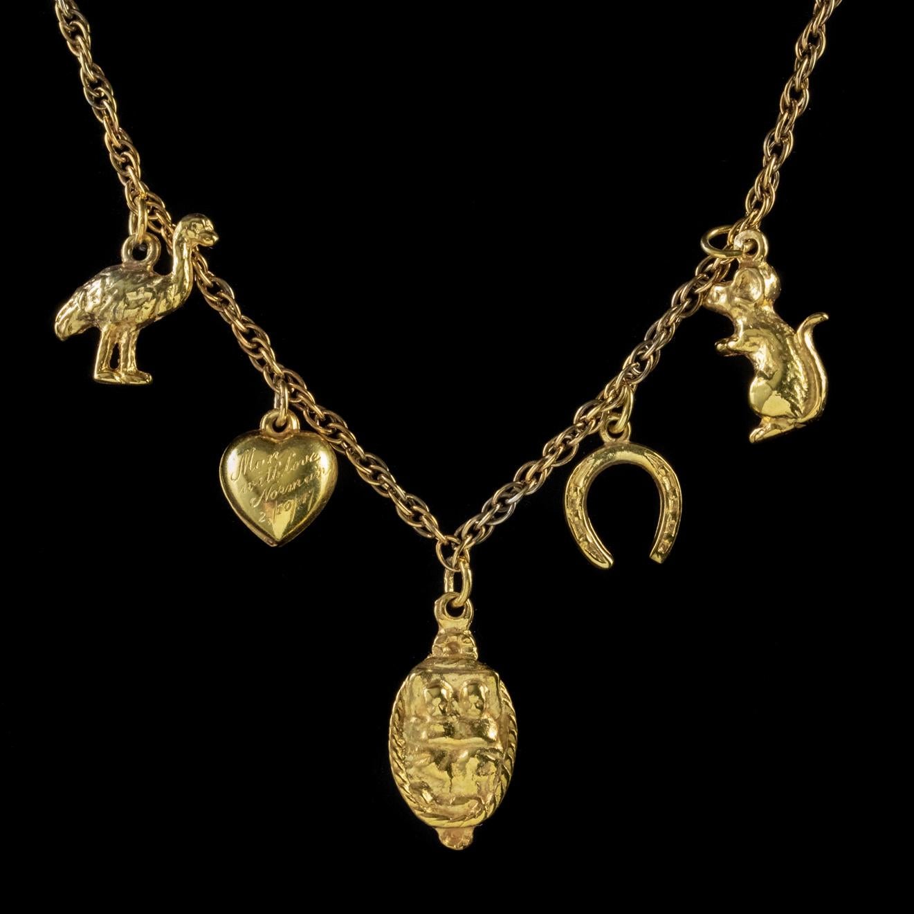 A highly unusual Vintage necklace crafted in Silver and gilded in 18ct Yellow Gold with an array of unique, three dimensional charms dotted throughout the chain. 

Each charm is solid and distinctive with expert engraved detailing. The charms