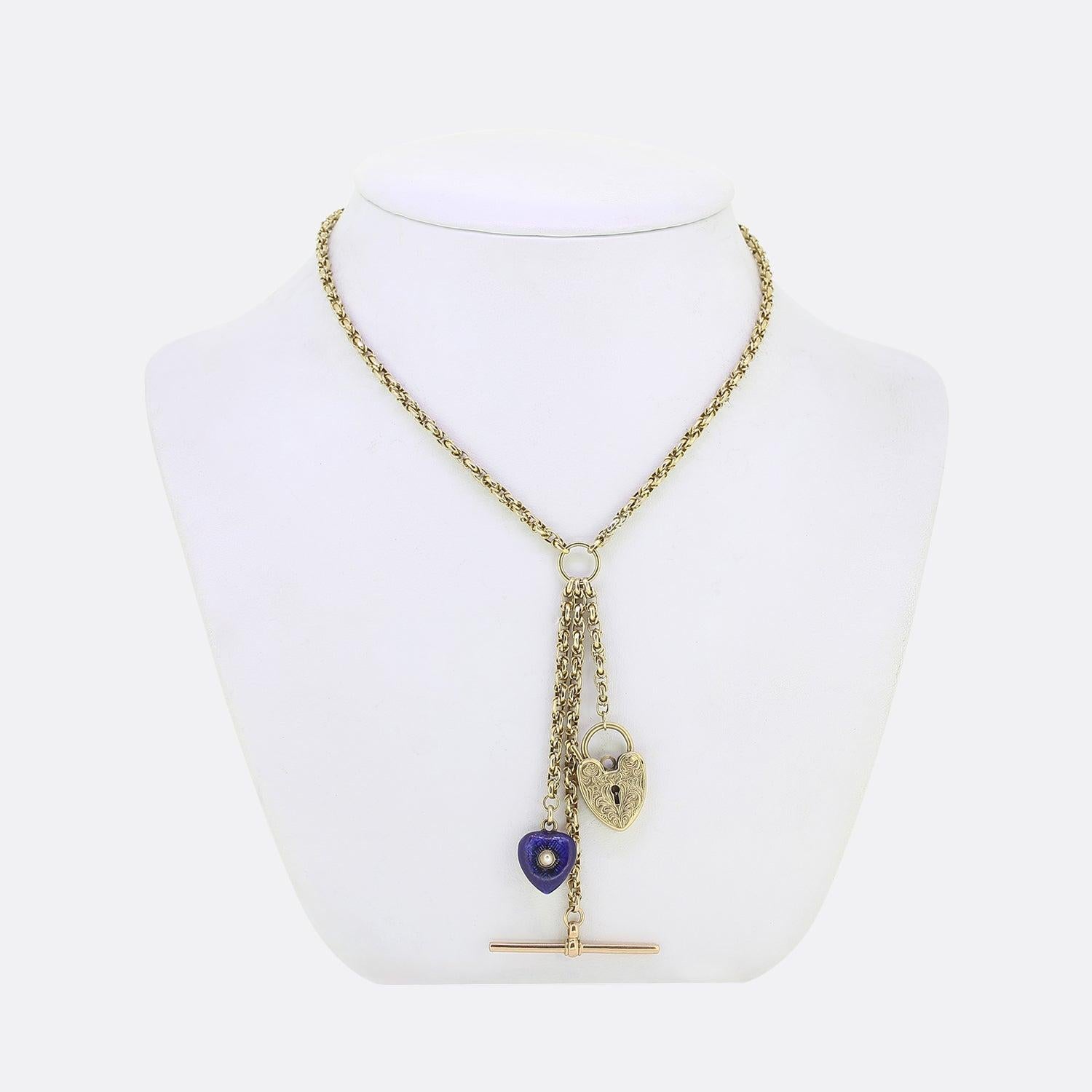 Here we have a vintage 9ct yellow gold belcher chain charm necklace. The chain itself is double linked and lightly rendered to showcase a faceted design. This lengthy chain plays host to a trio of pendants including an ornately engraved padlock, a