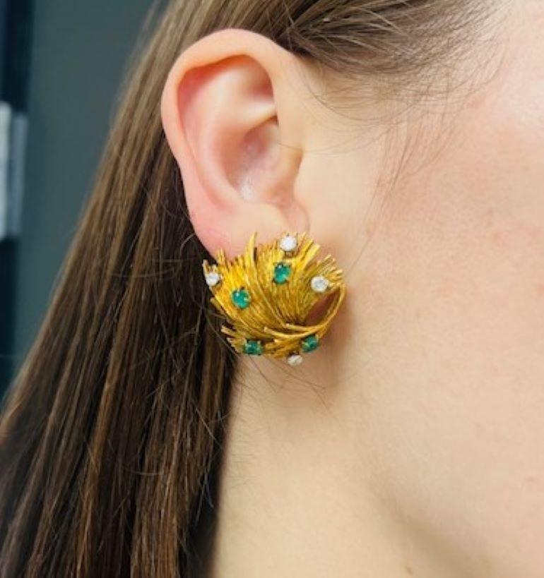 A pair of rare vintage Chaumet earrings made of 18k gold, featuring emerald and diamond. 
The earrings have an abstract round shape with torn edges that resemble fire flames or leaves. The dynamic shape was achieved by masterfully assembling