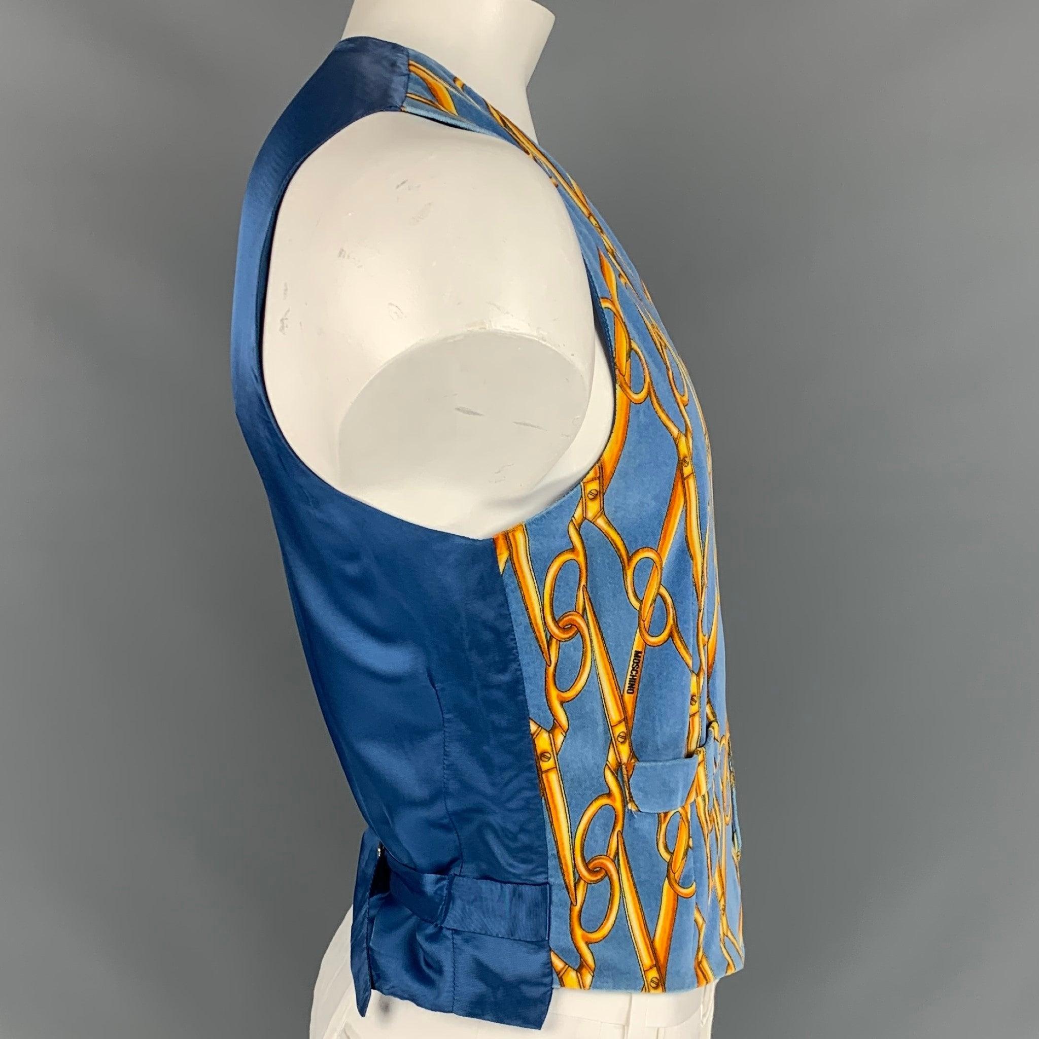 Vintage CHEAP and CHIC by MOSCHINO vest comes in a blue & yellow scissor print velvet featuring a back belt, slit pockets, and a buttoned closure. Made in italy.
 Very Good
 Pre-Owned Condition. 
 

 Marked:  I 52 / E 52 / GB 42 / USA 42 
 

