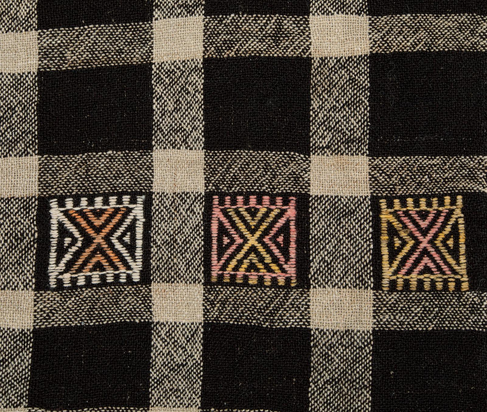 Esta alfombra vintage de tejido plano se fabricó en Turquía, hacia mediados del siglo XX. Utilizando antiguas técnicas de fabricación de alfombras, los tejedores artesanos elaboraron esta alfombra con la mejor lana hilada a mano y teñida totalmente