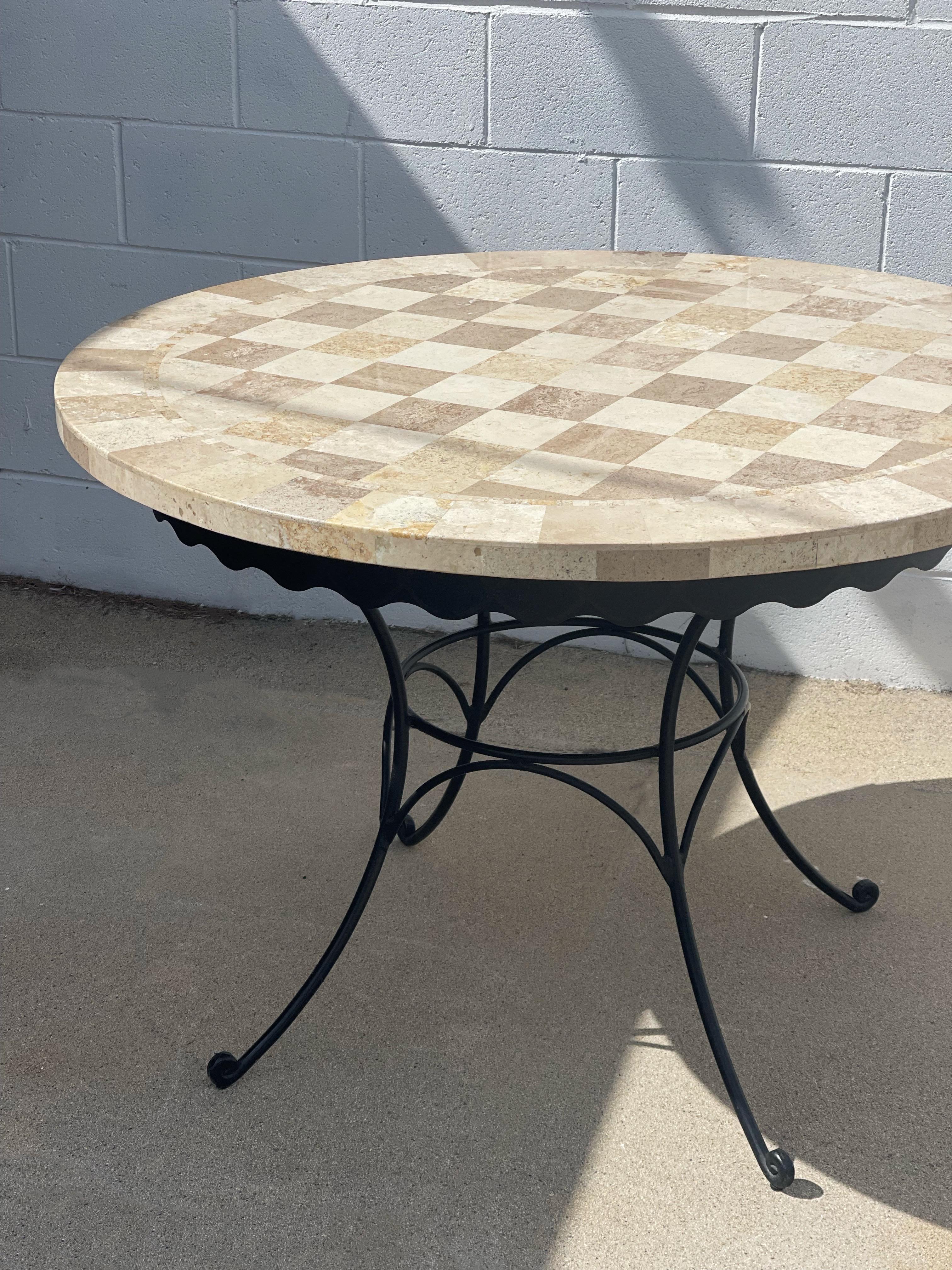 Checkered stone table top with a wrought iron scalloped base. Great for a breakfast nook or sheltered patio. In beautiful condition.