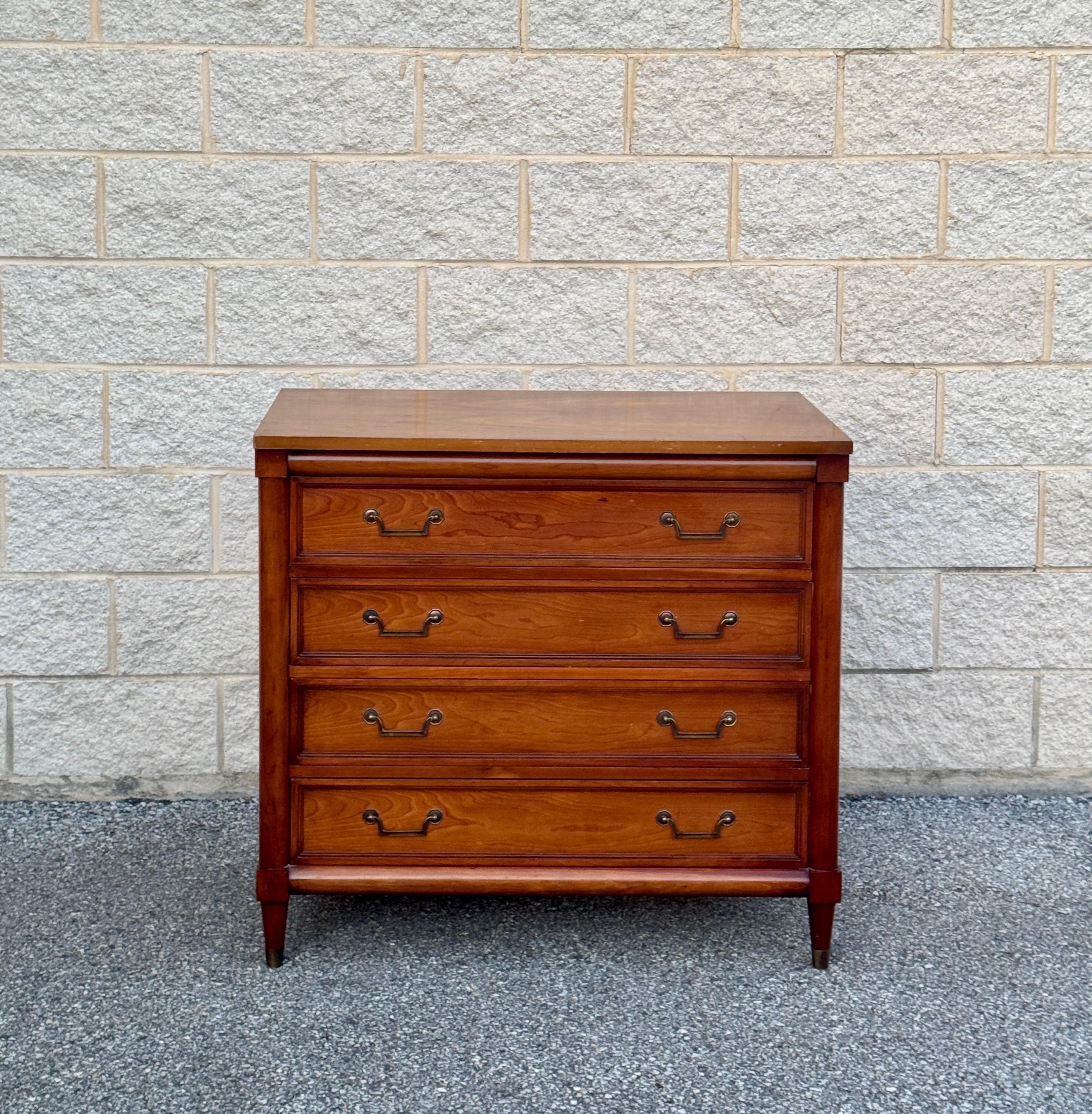 Elegant vintage 4-drawer dresser in cherry wood construction and classic design. Featuring original brass hardware and tapered legs, perfect as a standalone piece or as part of a curated vintage-inspired interior.
