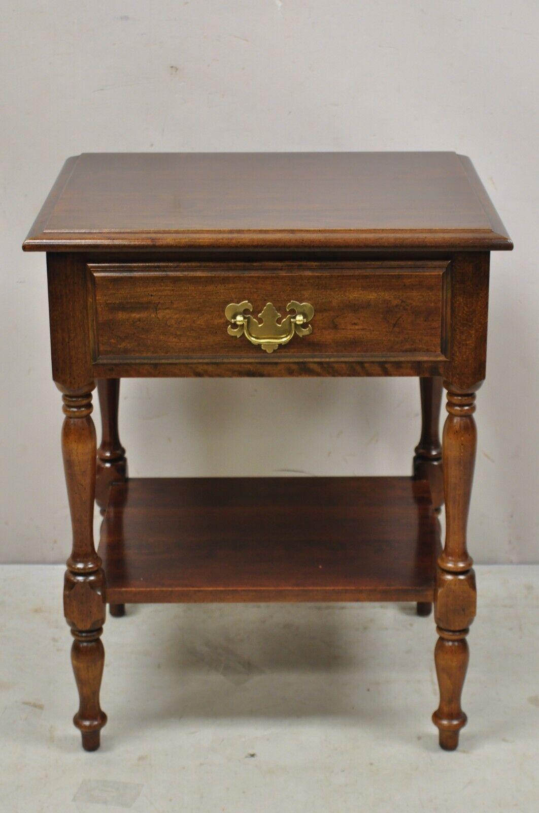 Vintage cherry wood colonial style one drawer nightstand bedside end table. Item features a lower shelf, solid wood construction, beautiful wood grain, 1 dovetailed drawer, quality American craftsmanship, great style ad form. Circa Late 20th