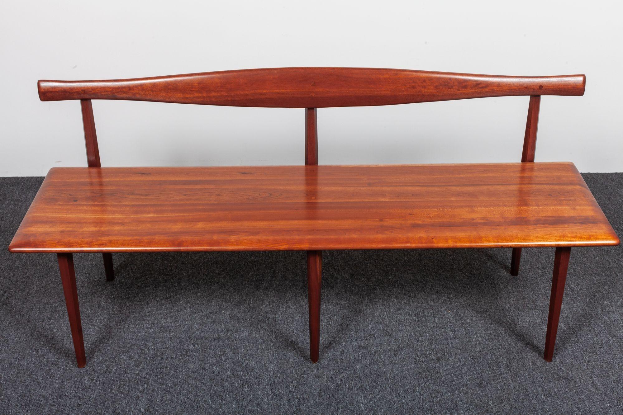 Solid cherrywood bench designed by Kipp Stewart and Stewart McDougall for Winchedon (ca. 1950s, USA).
Composed of a deeply carved, cow horn-form backrest and minimal rectangular platform seat, all supported by elegant, tapered legs.
Conservatively