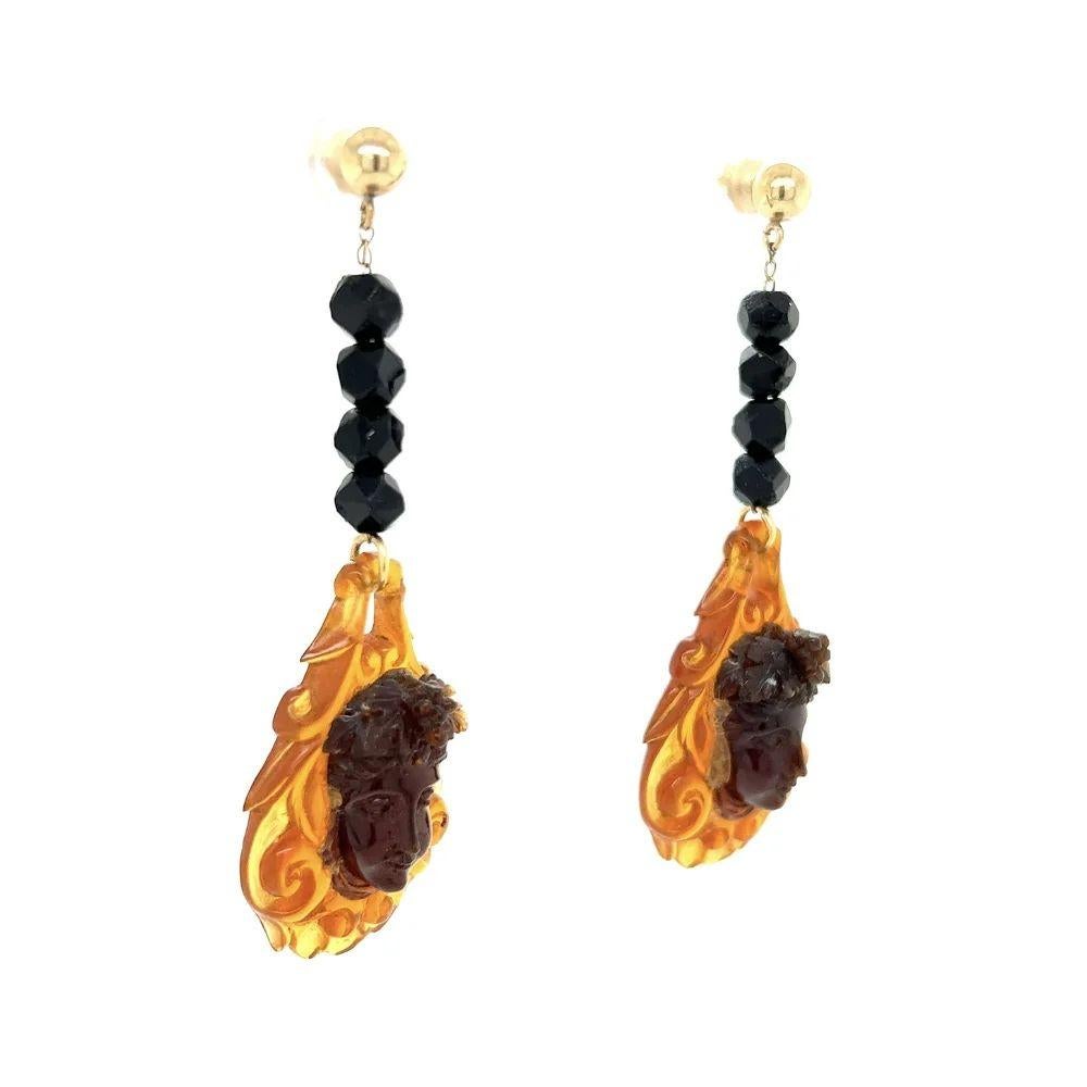 Semplicemente bello! Coppia di orecchini a goccia in oro con facce di cherubino e ambra intagliata. Orecchini a goccia in ambra intagliata a mano con facce di cherubino. Montatura in oro giallo 14K.  Lunghezza circa 2.5