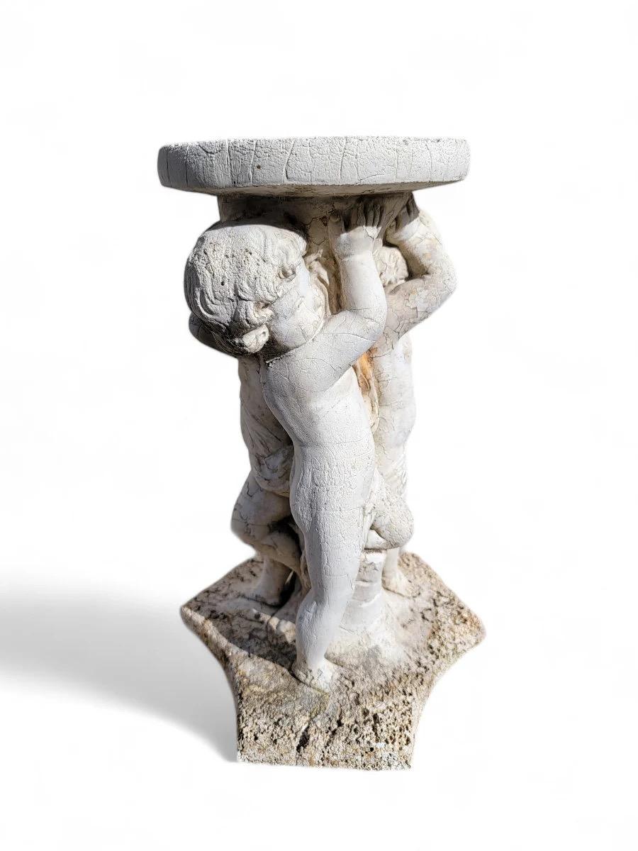 Portapiante/tavolino da giardino Cherub Putti d'epoca 

Questo piedistallo circolare vintage presenta tre putti che sorreggono un piano rotondo. La sua finitura rustica e grezza la rende un accento perfetto per il tuo giardino o il tuo patio. Può