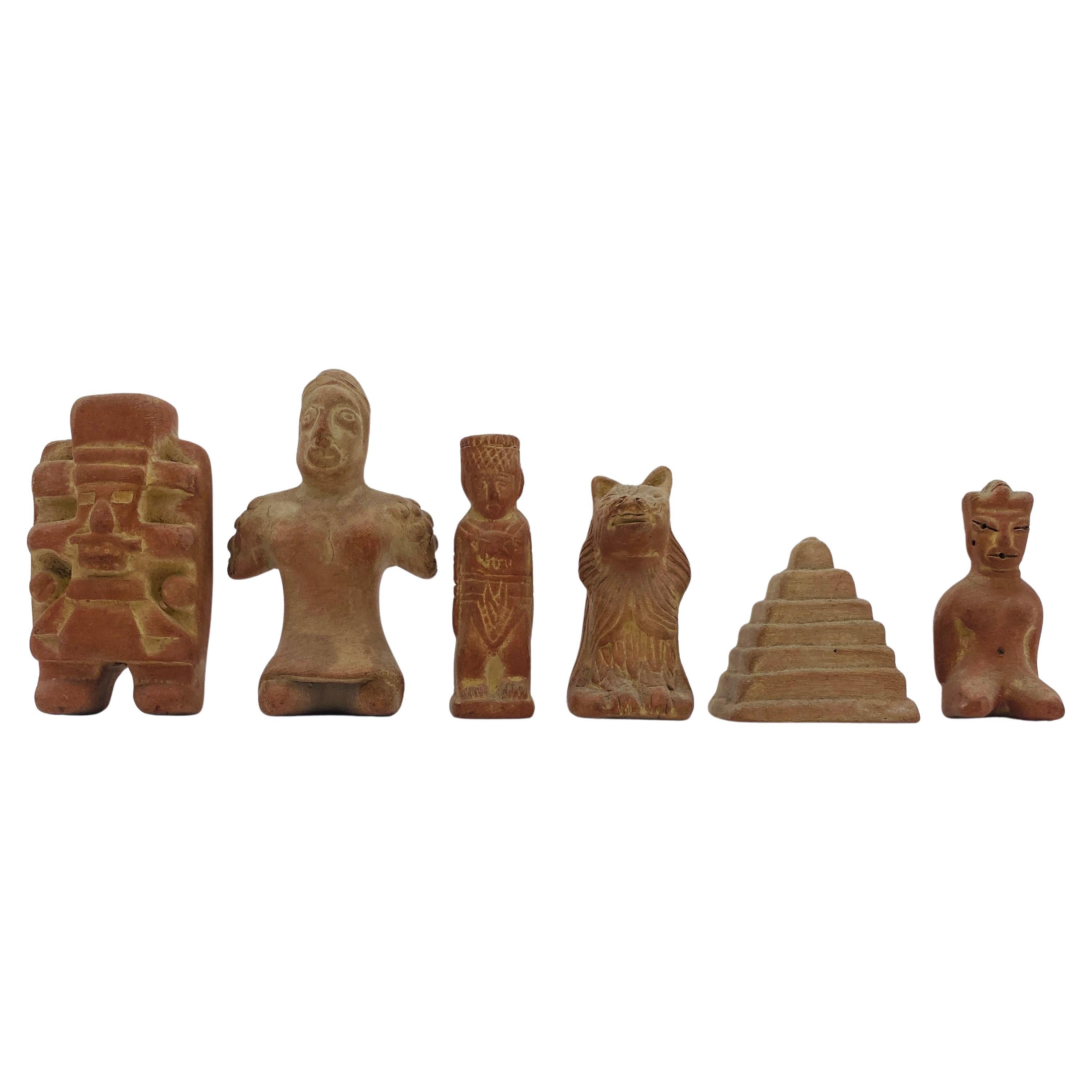 This is a rare 20th-century chess set made with terracotta and wood in Mexico. The figurines are in the style of pre-Columbian Aztec Gods, warriors, and pyramids. The tiled board has a built-in wooden storage drawer decorated with terracotta