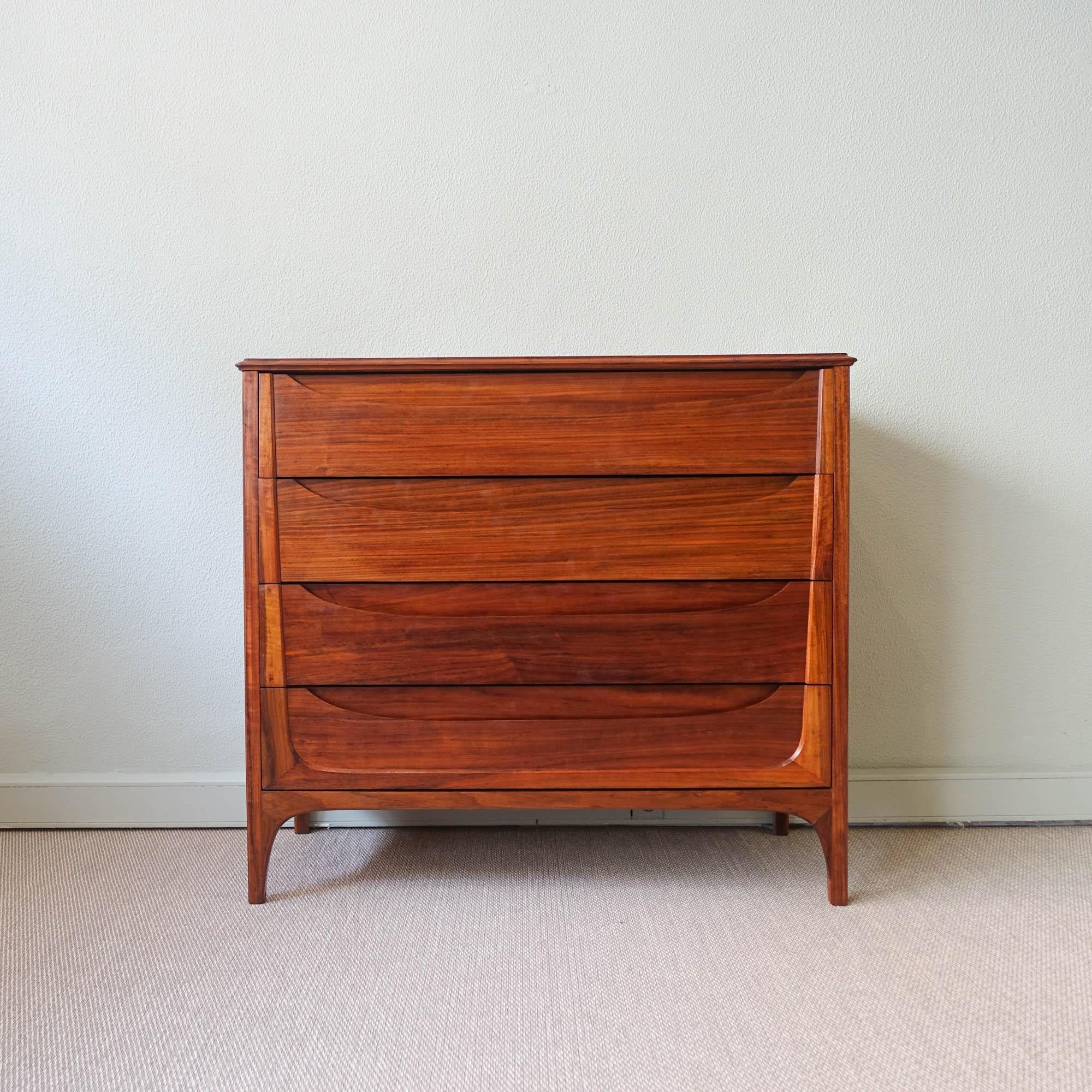 This chest of drawers was designed by José Cruz de Carvalho and produced by Altamira, in Portugal, during the 1960's. It is made of mutenye wood with hidden handles. It features four drawers in total with a very elegant design. It was completely