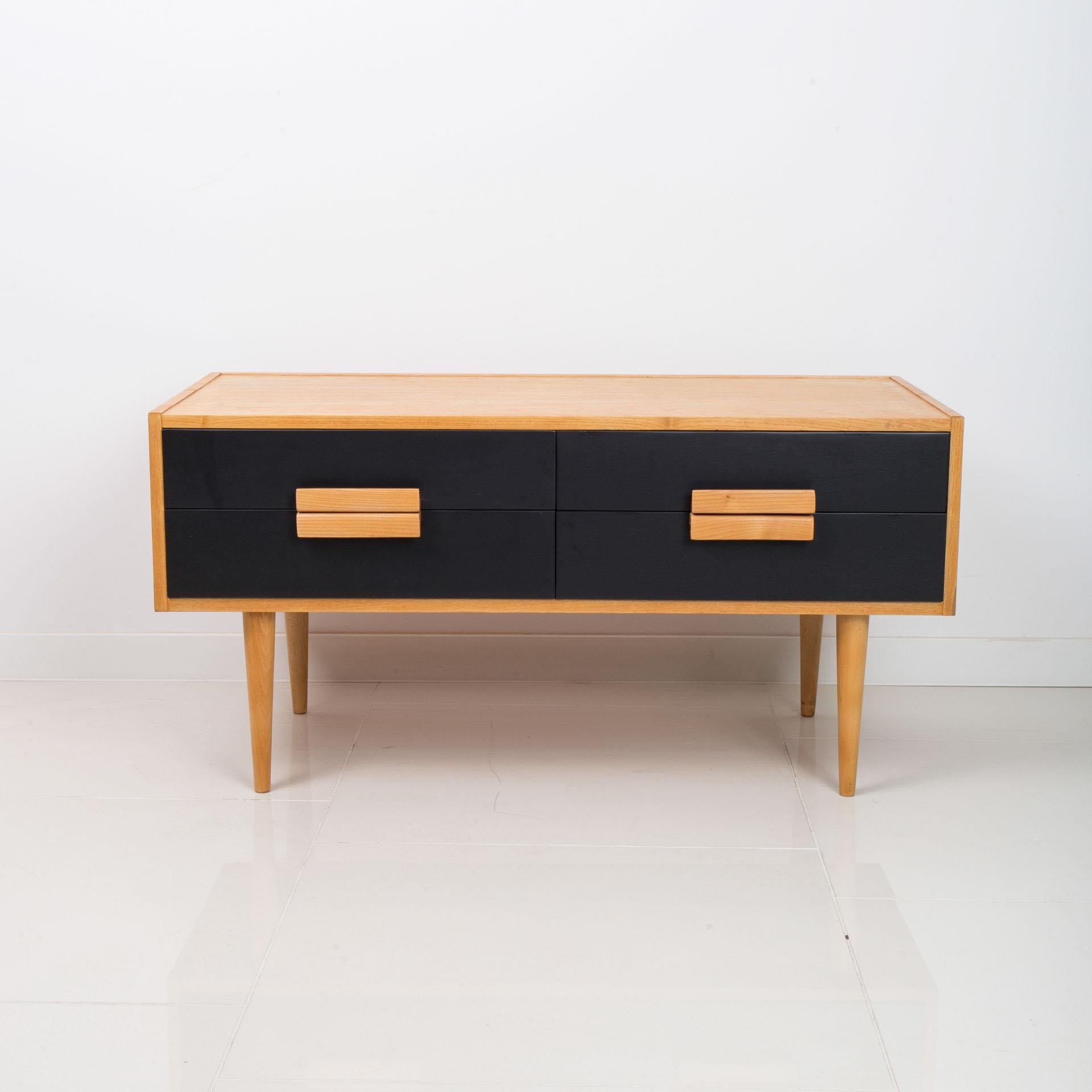 This four-drawer chest of drawers comes from Czechoslovakia from around 1960s. The piece is in very good condition - it underwent careful renovation process. It is veneered with ash veneer. The fronts of the drawers were varnished in black matt. The